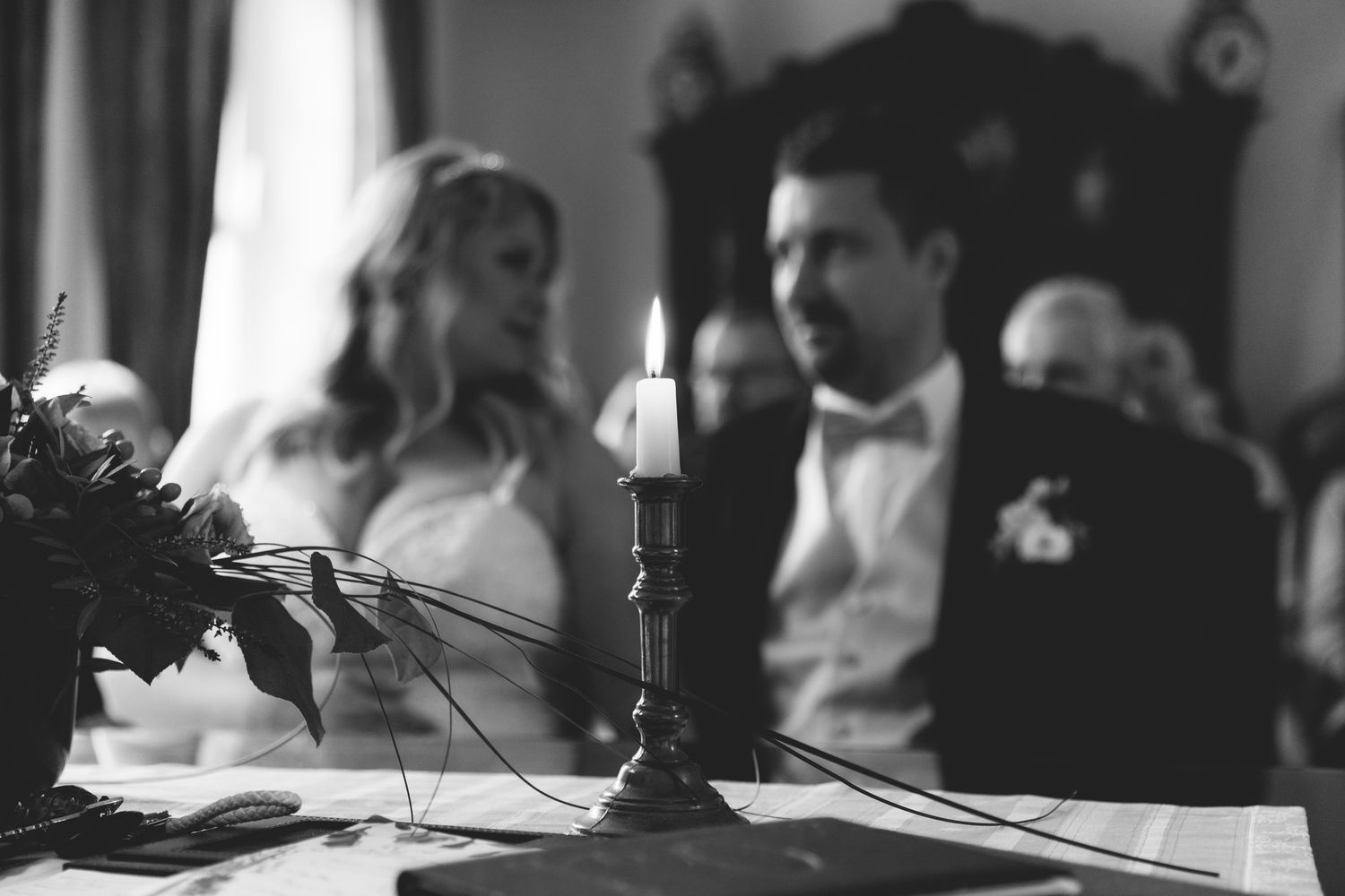 A black and white photo montage showing wedding ceremony moments with candlelight and formal attire.