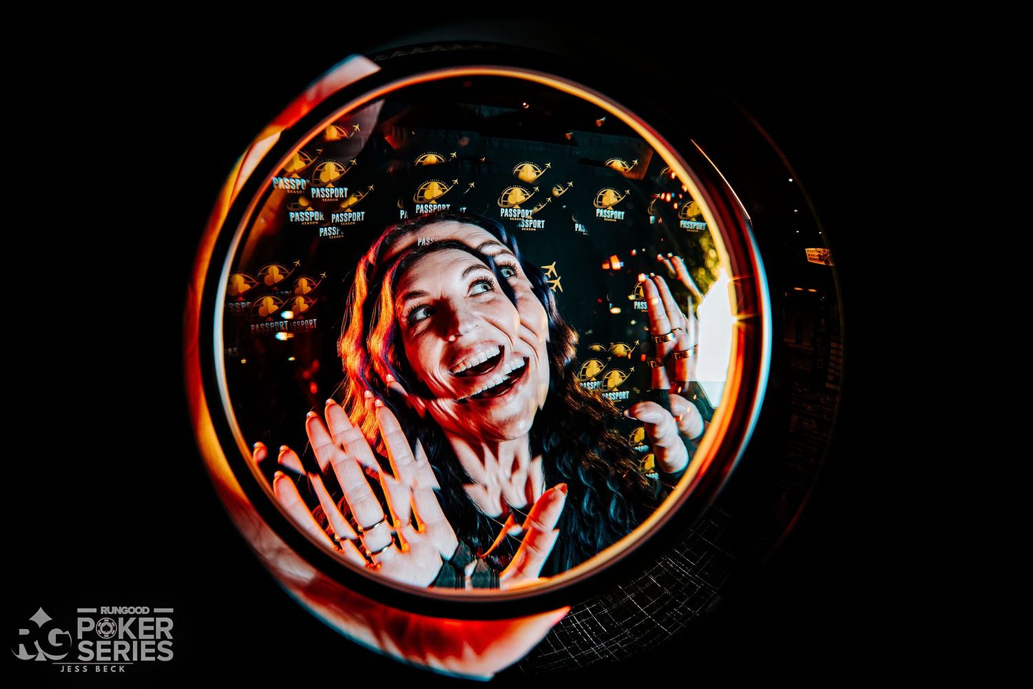 Woman smiling joyfully viewed through a circular lens with colorful bokeh lights at a Poker Series event.