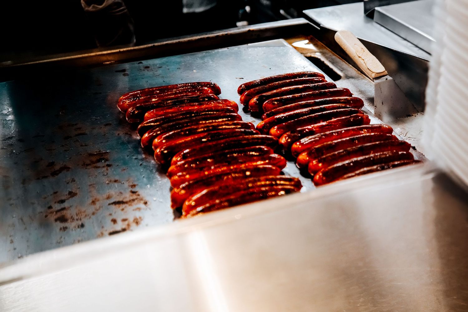 Raw ribs being grilled and smoked on a barbecue grill with smoke rising in the background.