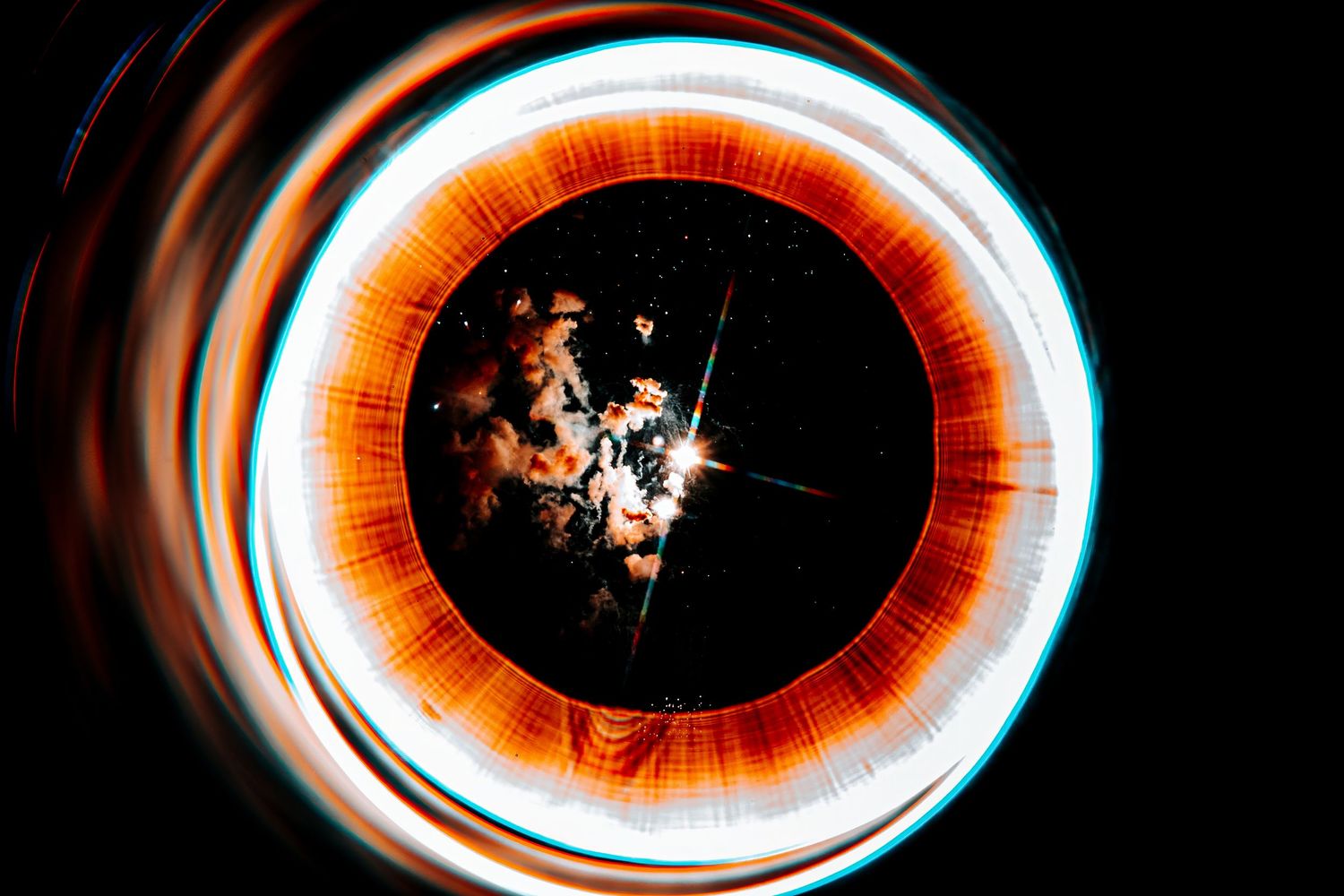 Abstract long exposure light painting with glowing orange and white circular rings on a dark background.
