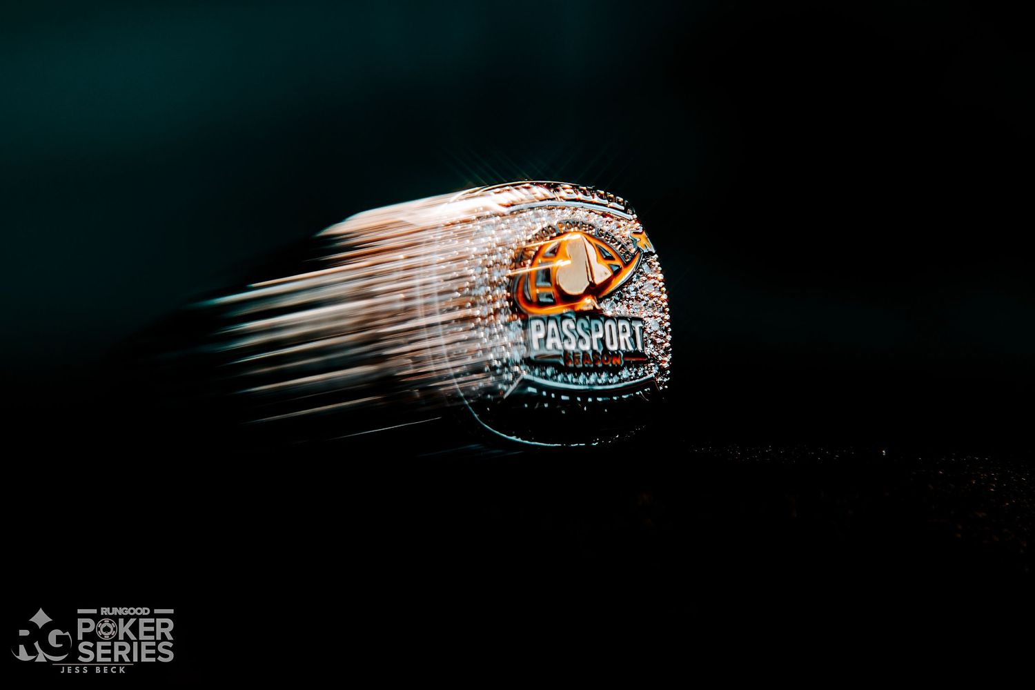 A spinning championship ring with gold and jewel details, captured in motion blur against a dark background at a Poker Series event.