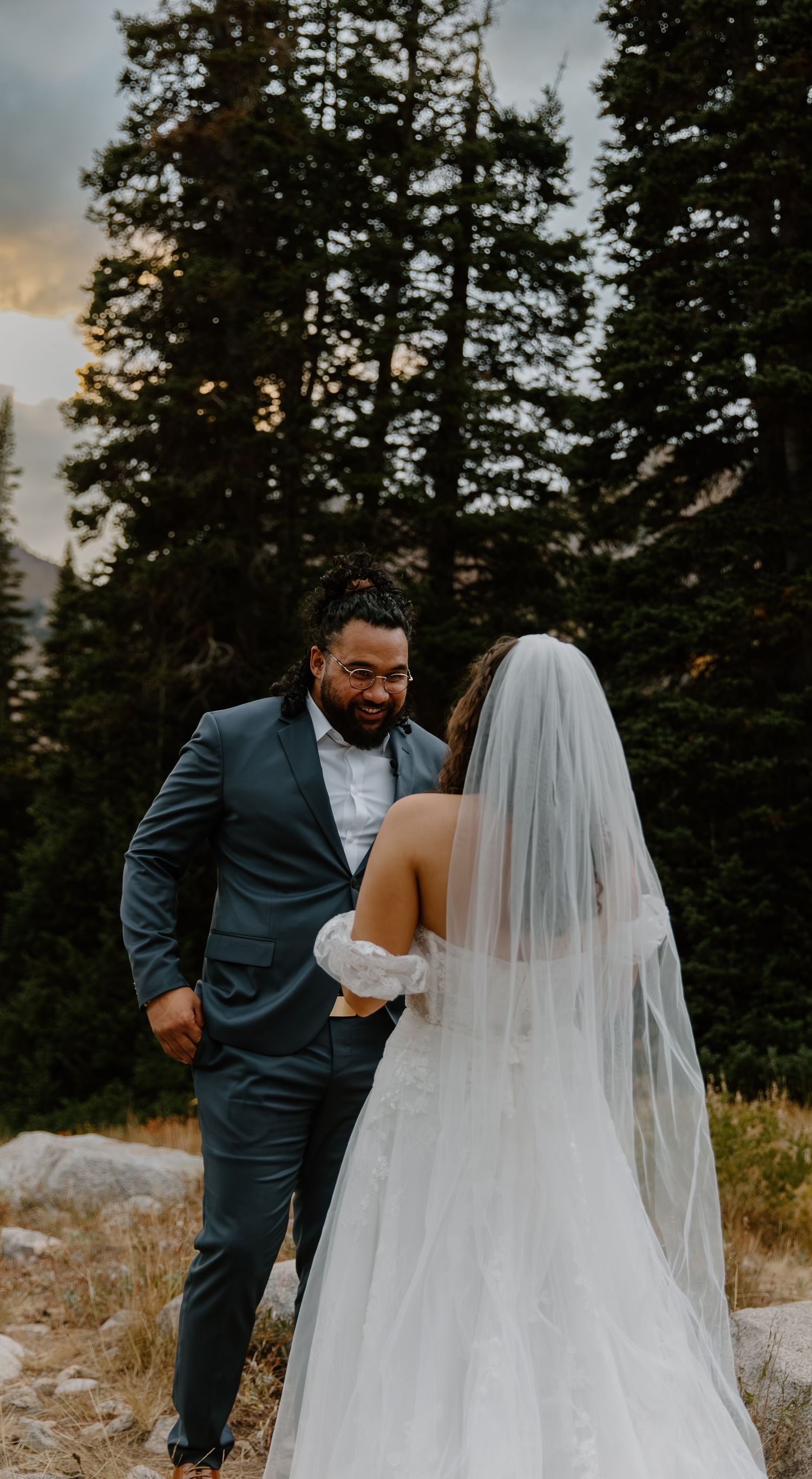 A couple shares an intimate moment during their mountain wedding photoshoot at sunset.