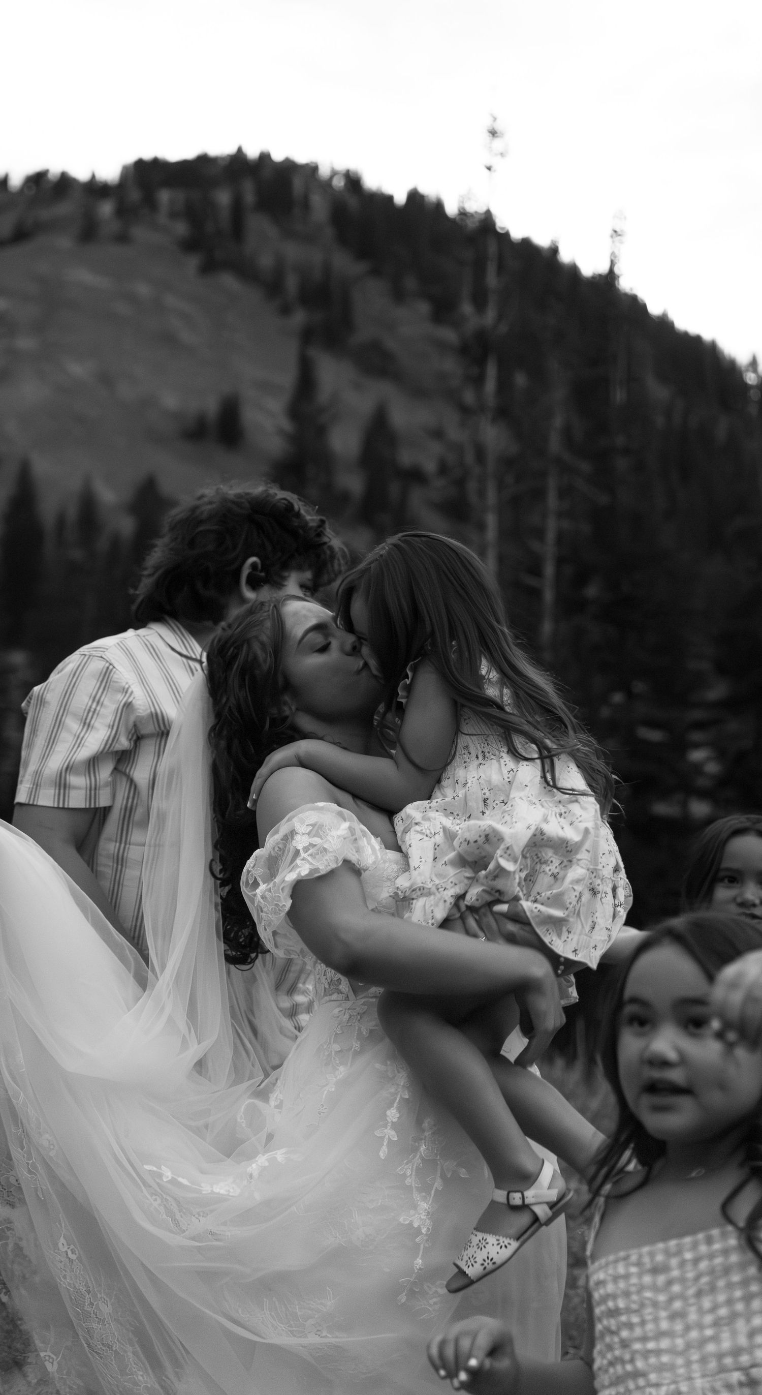 A series of black and white photos showing tender moments between two people in an outdoor mountain setting.