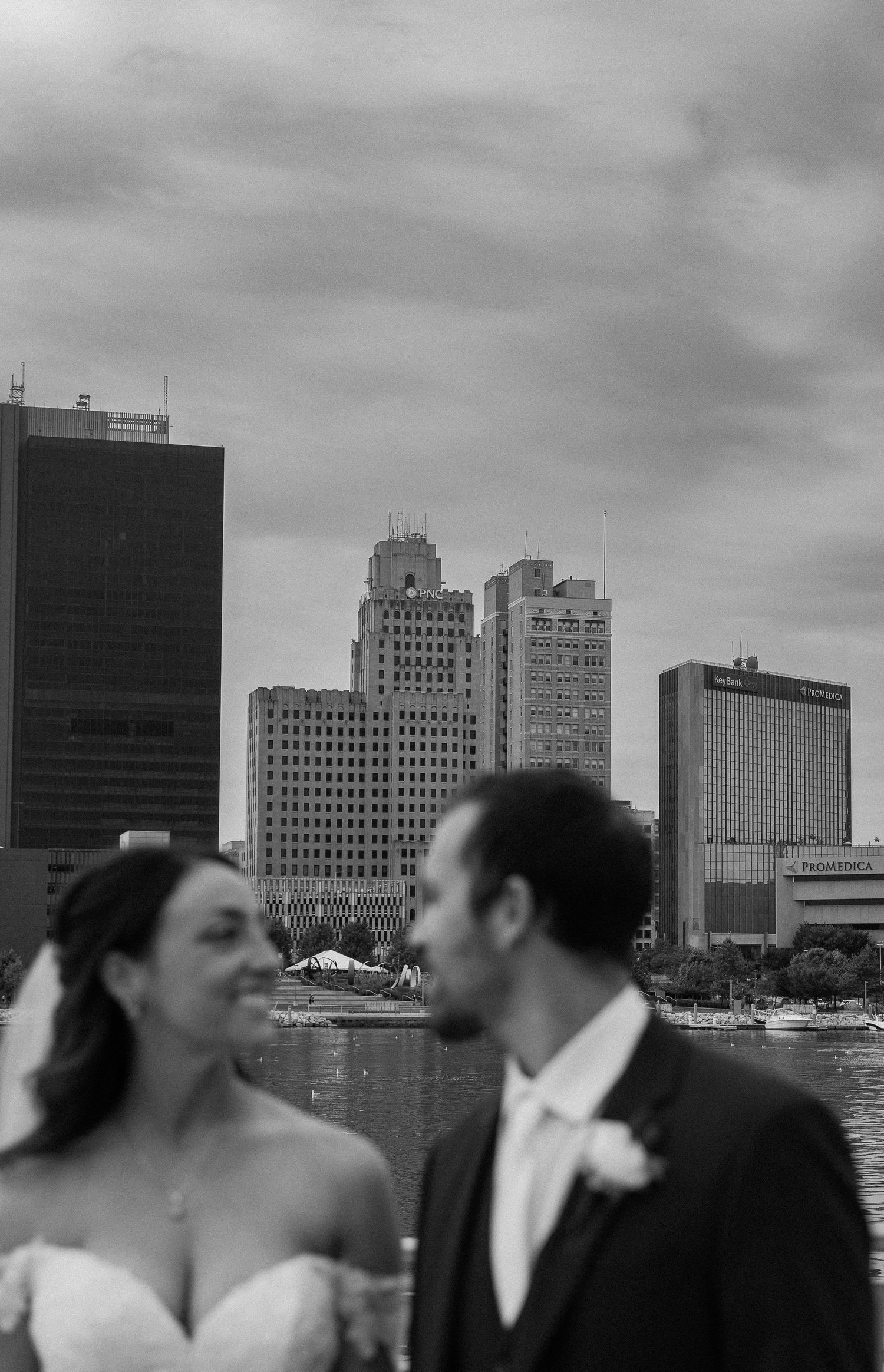 A romantic couple shares a tender moment against the Memphis skyline with tall buildings in the background.