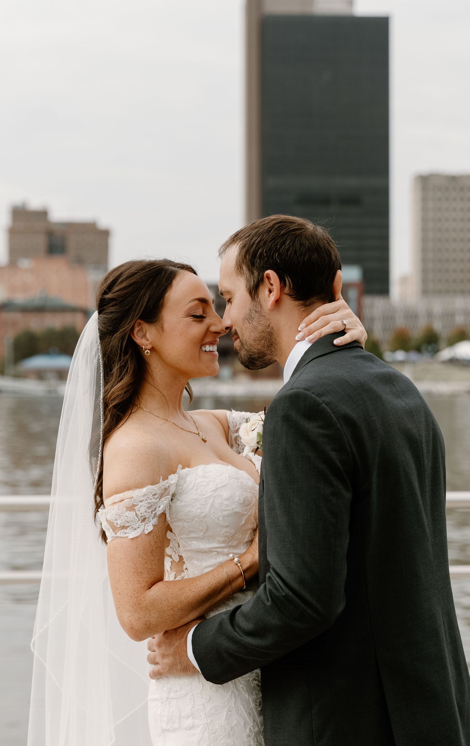 A romantic wedding moment captured in three sequential photos showing a couple embracing against a city skyline backdrop.