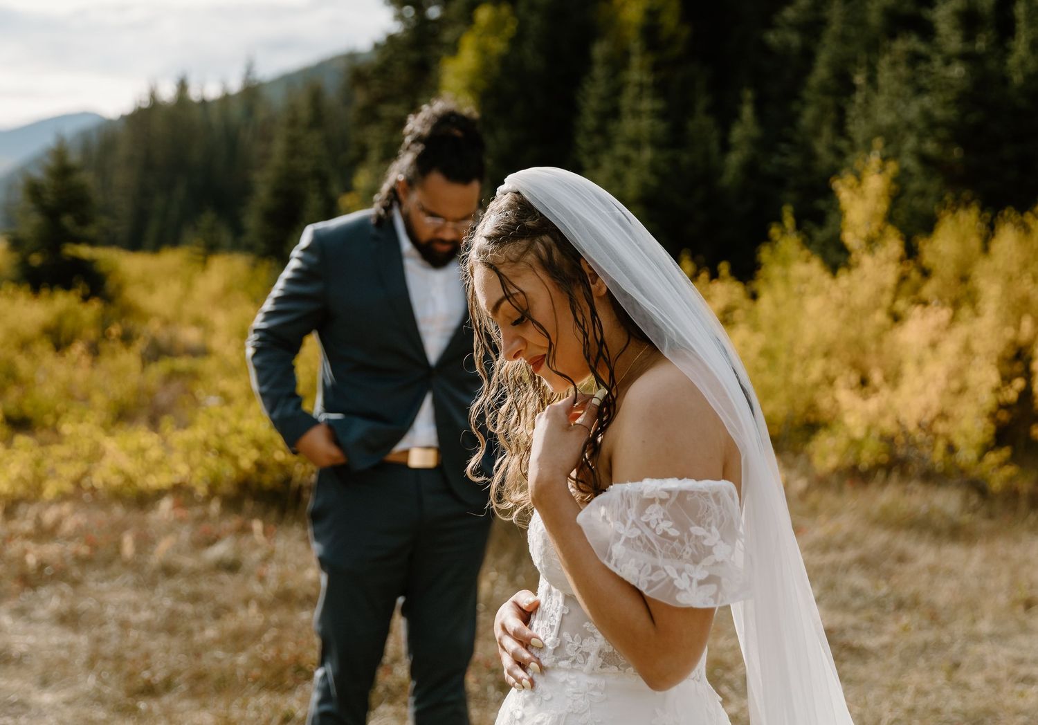 A beautiful wedding moment captured in a mountain meadow with golden autumn light.