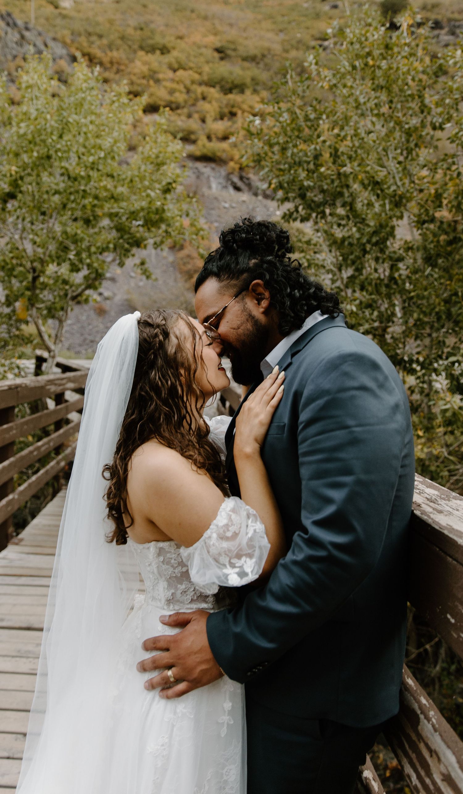 A romantic wedding sequence shows a couple sharing intimate kisses on a wooden bridge surrounded by autumn foliage.