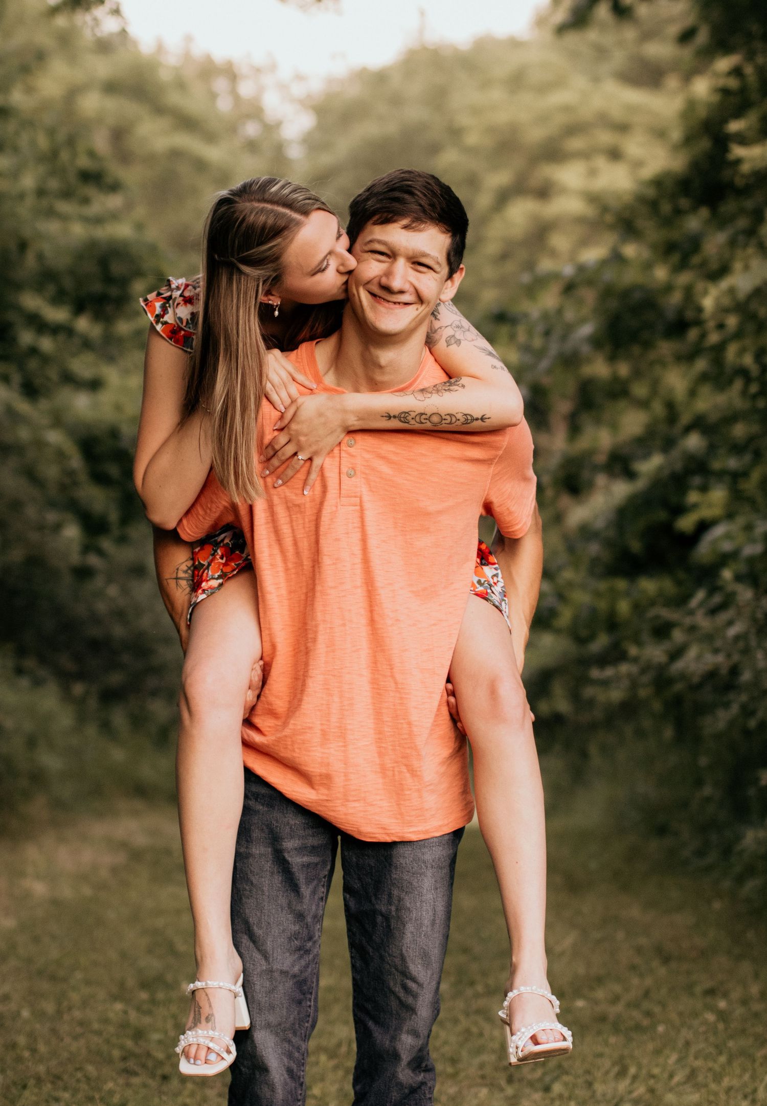 A playful piggyback ride moment captured outdoors with matching orange and floral outfits.