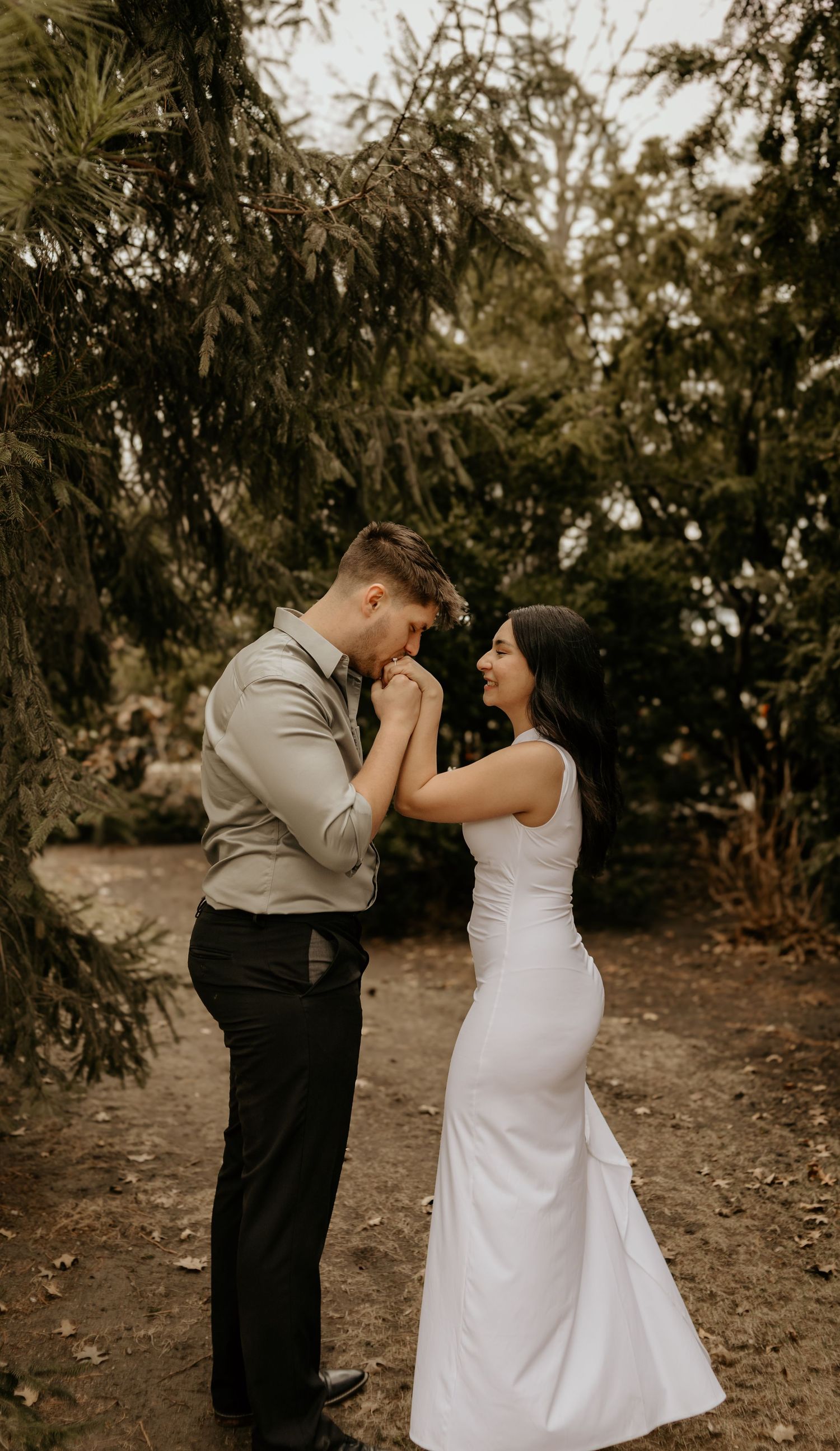 A couple shares a romantic moment on a nature path.