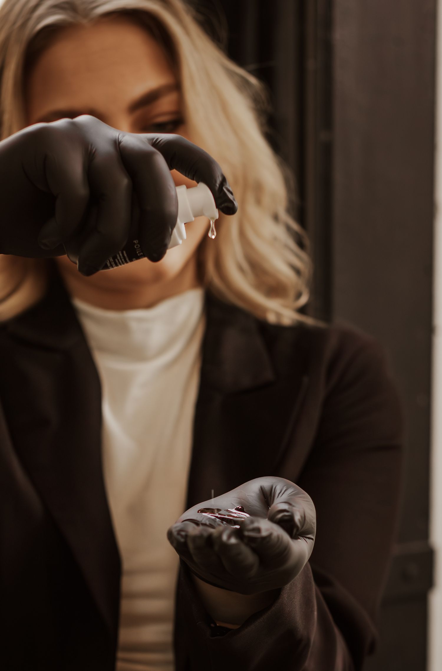 Close-up shot of hands in black gloves gesturing against soft indoor lighting.
