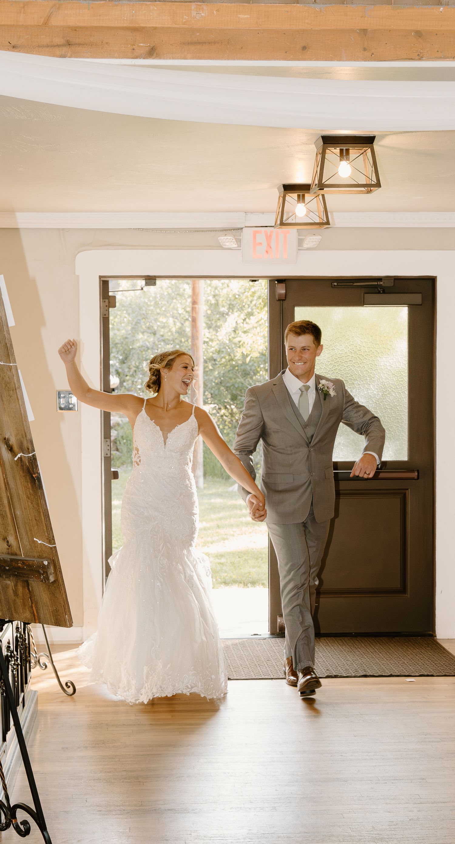 A wedding celebration entrance with elegant decor and lighting fixtures overhead.