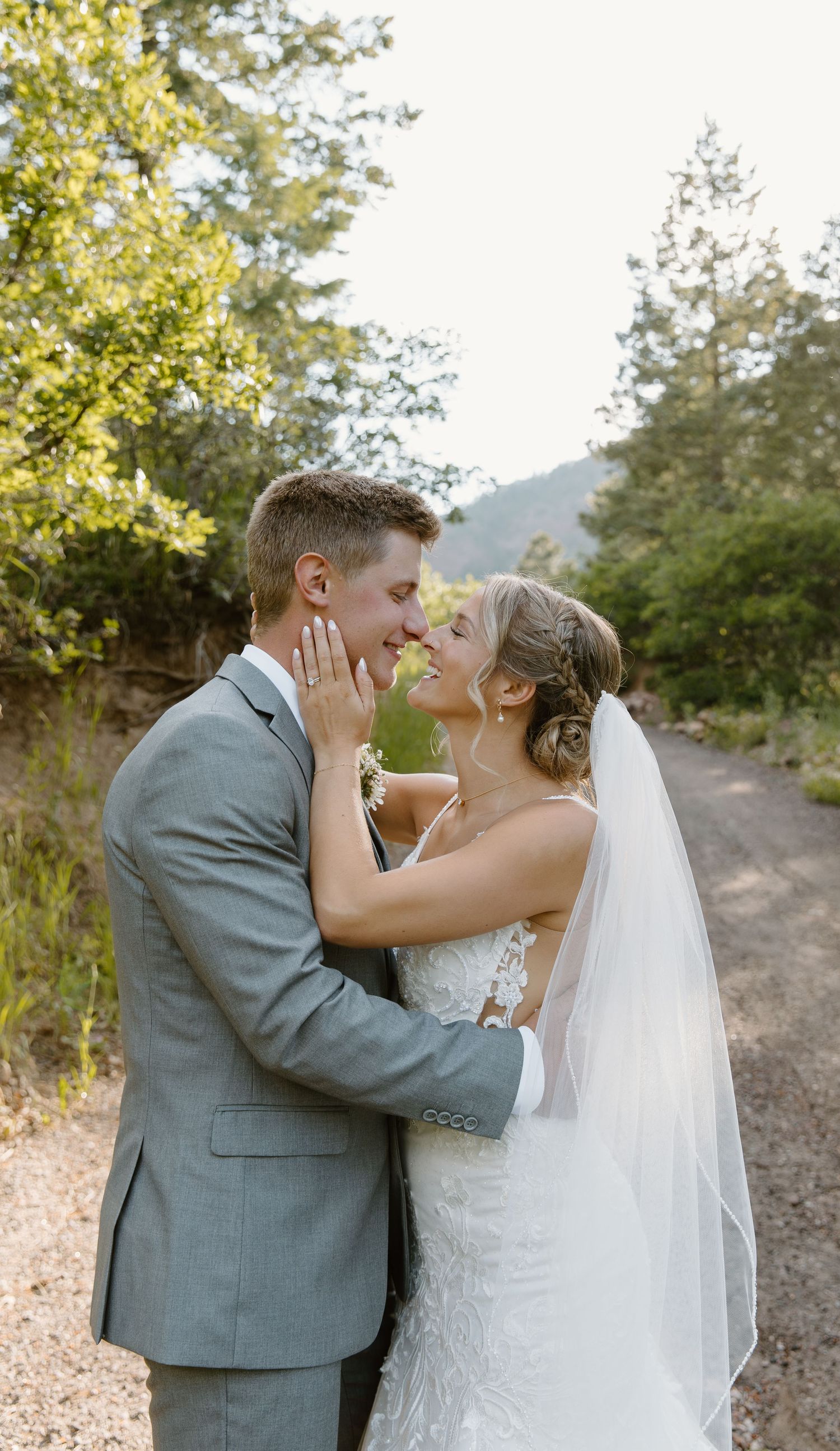 A romantic sequence of Colorado newlyweds sharing tender kisses during an outdoor wedding photoshoot on a dirt path with autumn foliage.