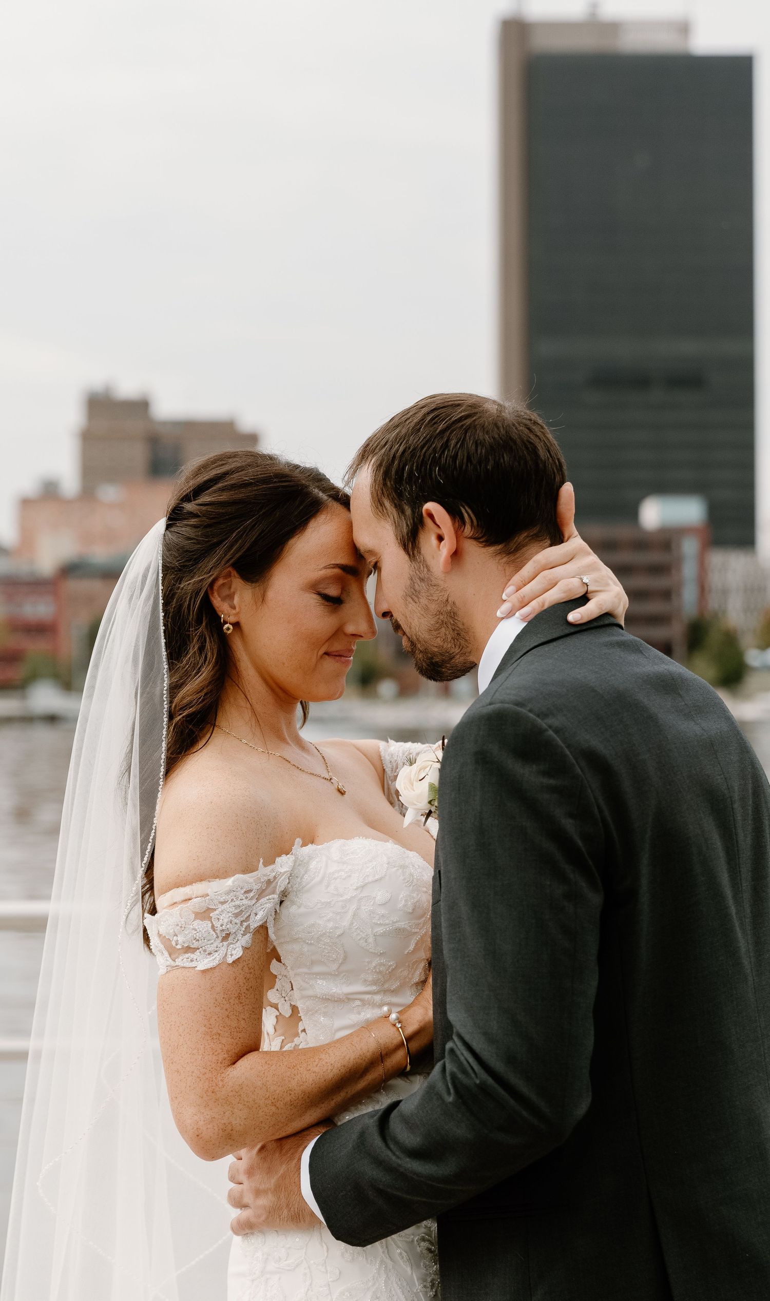 A series of romantic wedding portraits showing tender moments between newlyweds against an urban skyline backdrop.