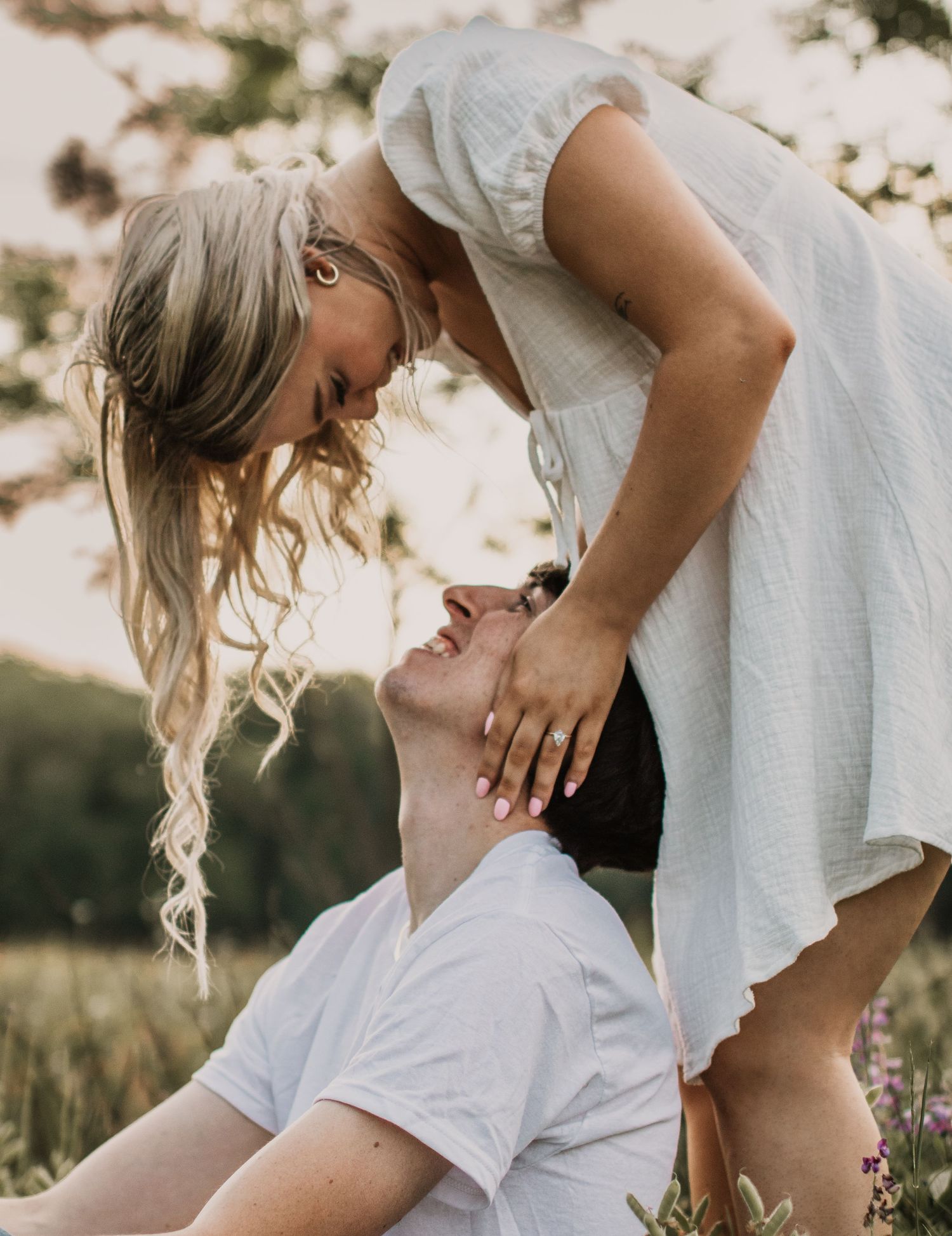 A romantic couple sharing a tender moment among wildflowers during golden hour.
