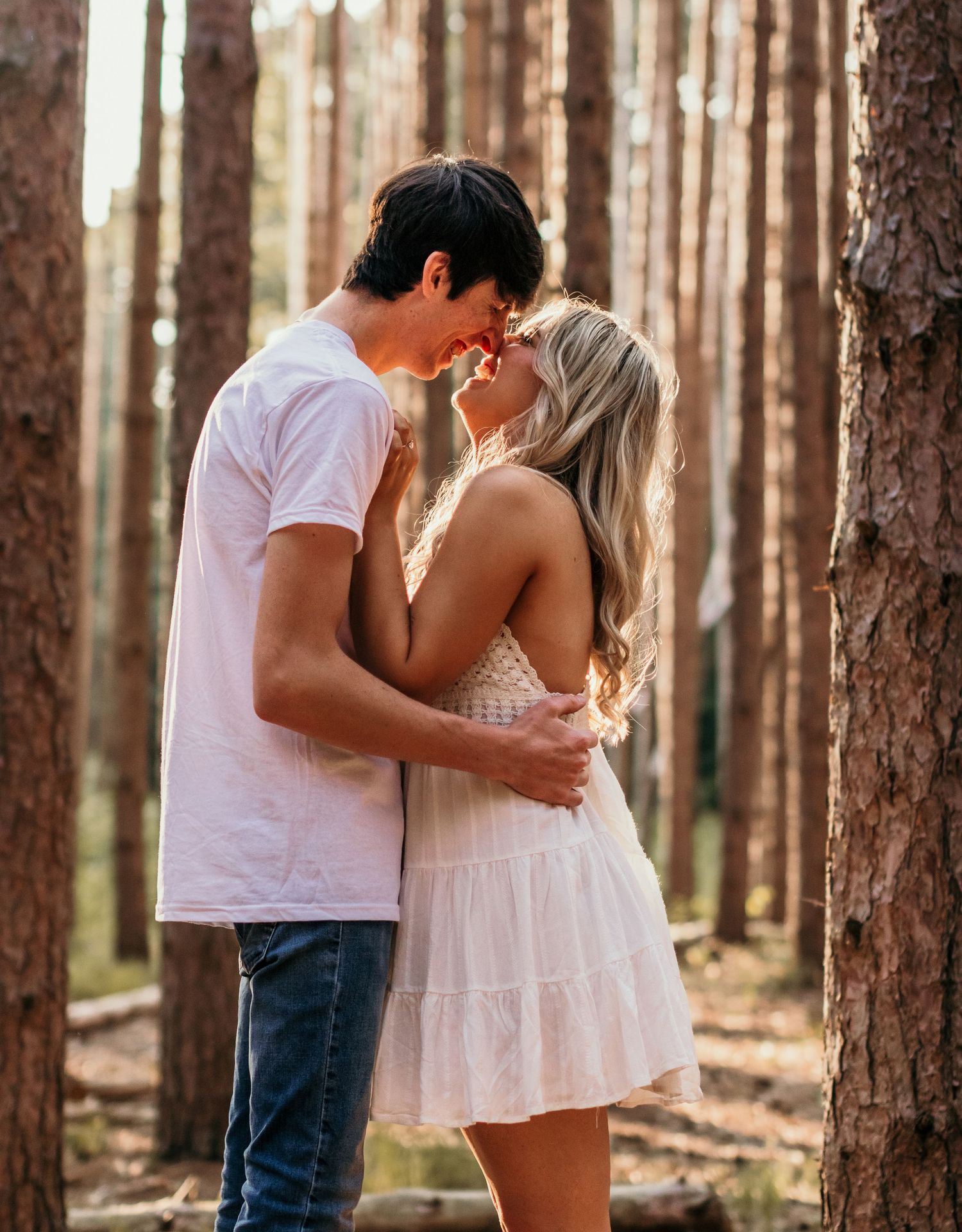 A romantic moment between a couple in a pine forest.