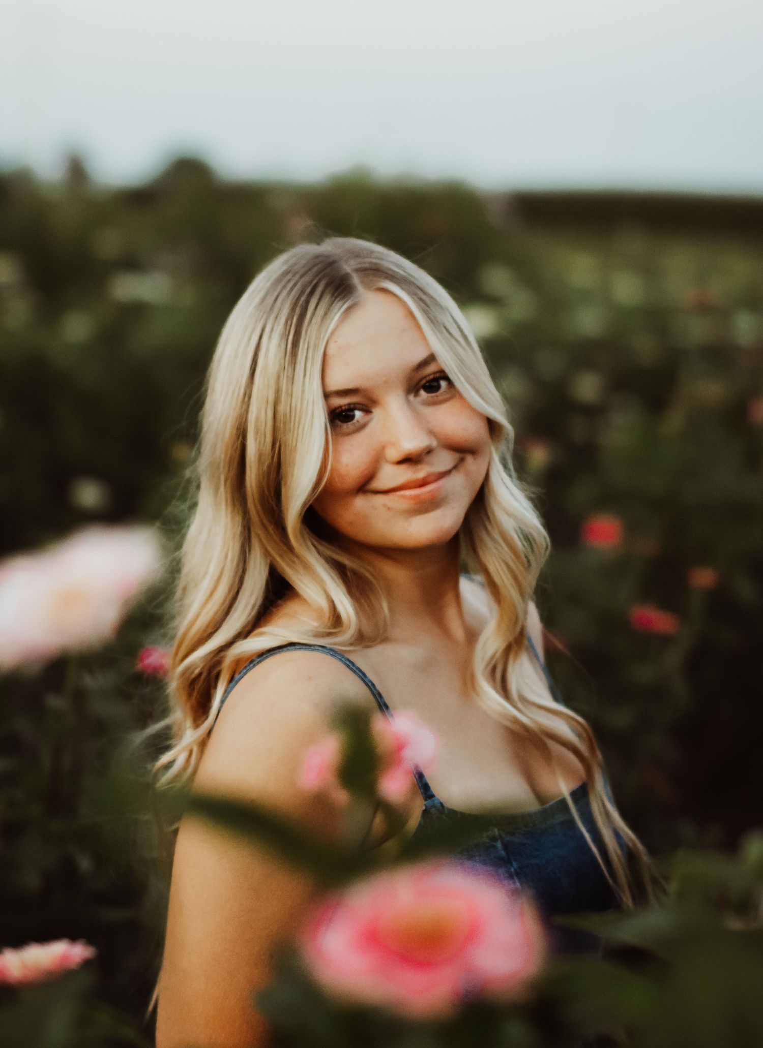 Outdoor portrait in a garden with summer flowers and natural lighting creating a warm atmosphere.