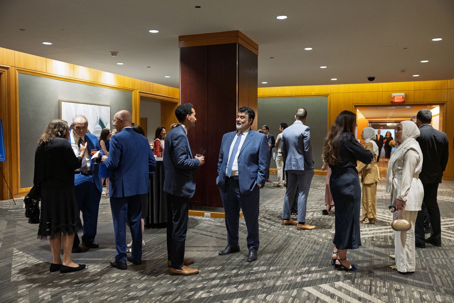 Business professionals networking and mingling in a hotel conference space during a corporate event.