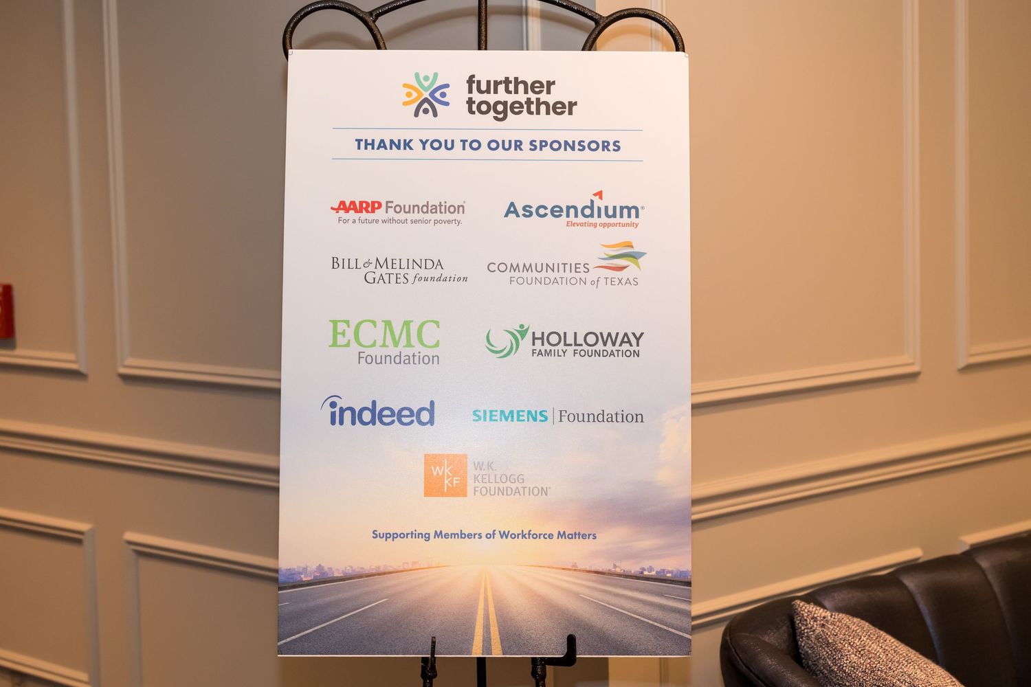 Corporate sponsor logos displayed on white banners at a professional conference or event venue.