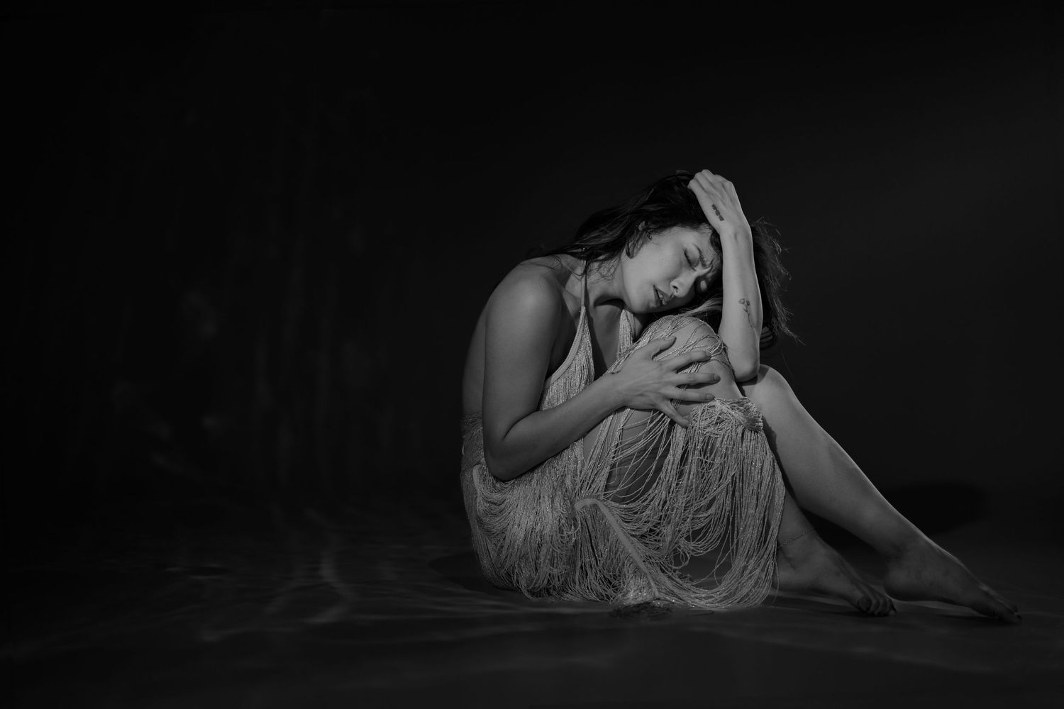 Artistic black and white boudoir photo sequence showing intimate poses of a person reclining in dim lighting.