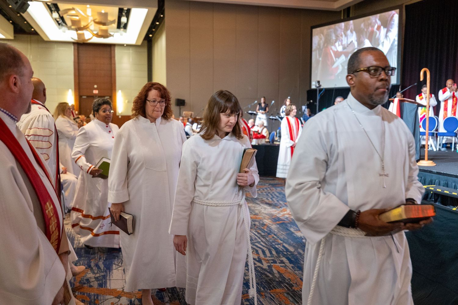 Medical professionals in white coats gather around tables at a professional networking or training event.