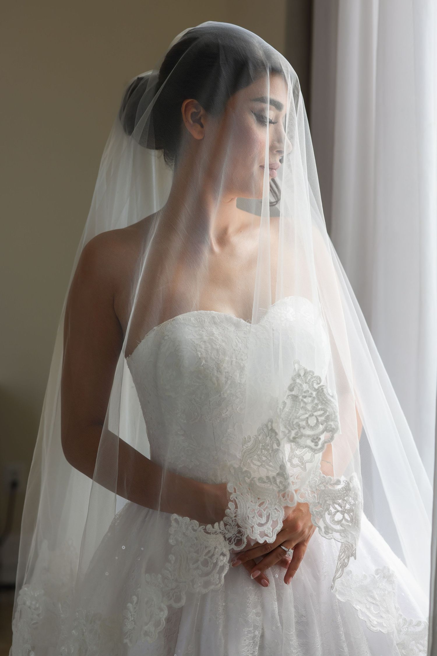 A series of wedding photos showing a bride in a white lace gown and flowing veil against a light background.