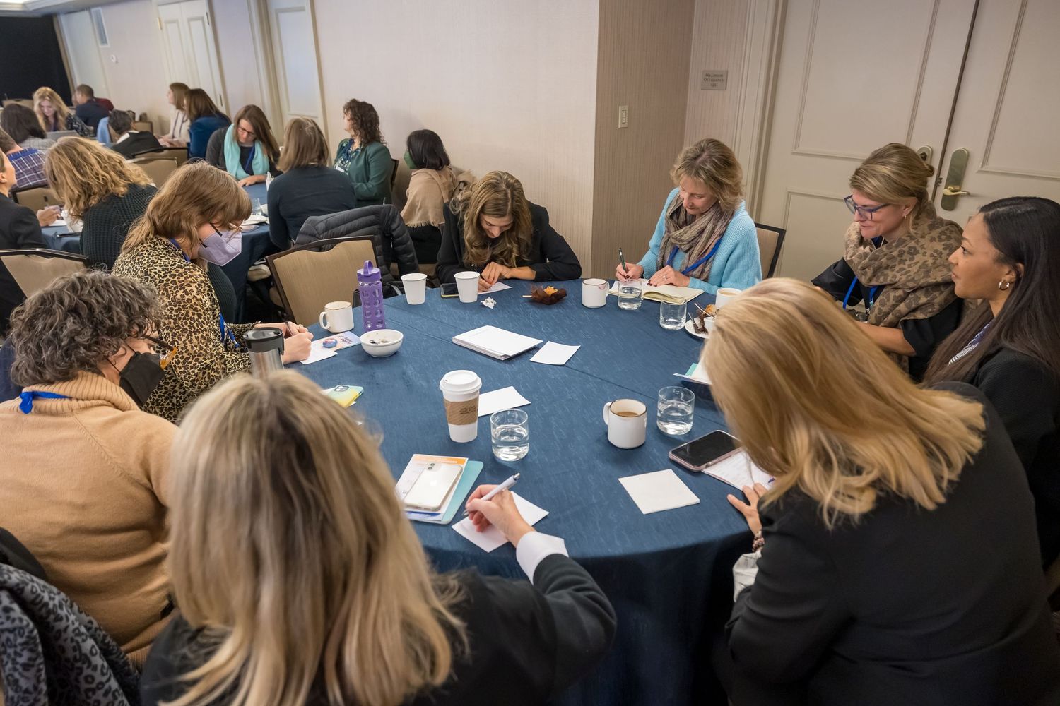 Business professionals gathered around a conference table for a meeting with papers and discussion materials.