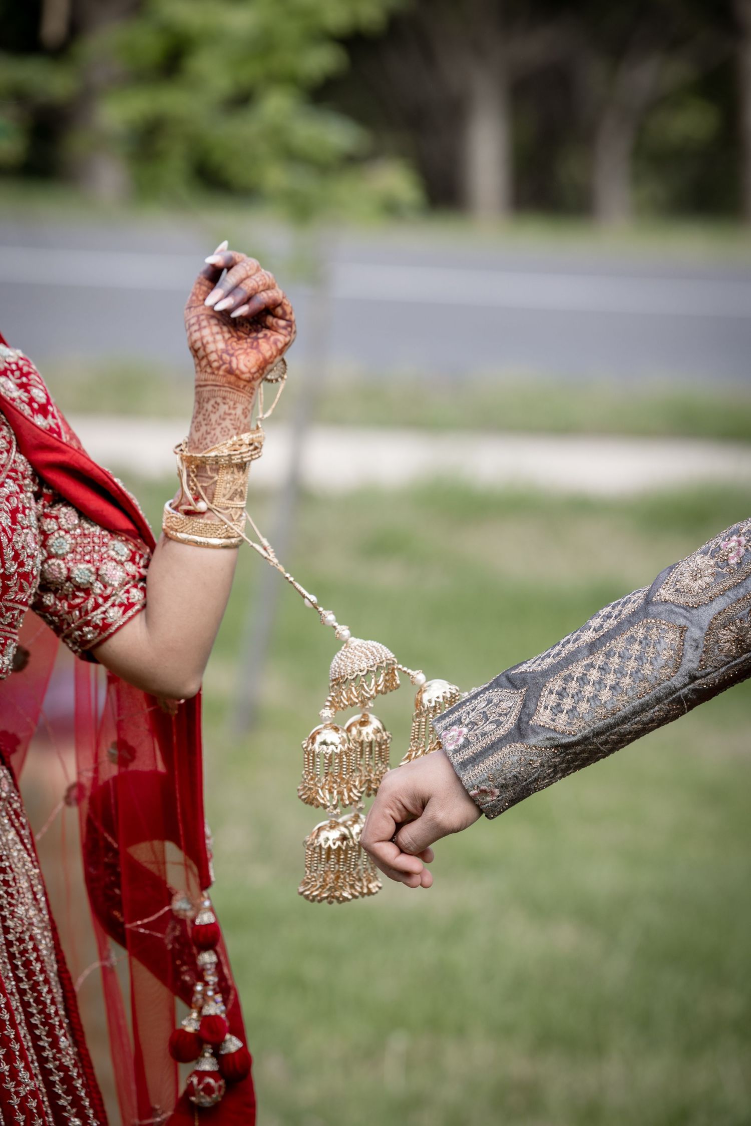 Close-up of traditional Indian wedding kalire ceremony with decorated wrists and hands.
