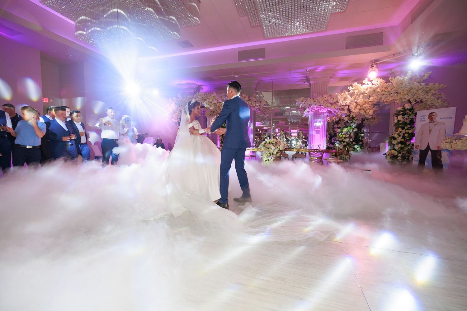 Fog machine creates a dreamy atmosphere on a dance floor with purple lighting and decorative chandeliers.
