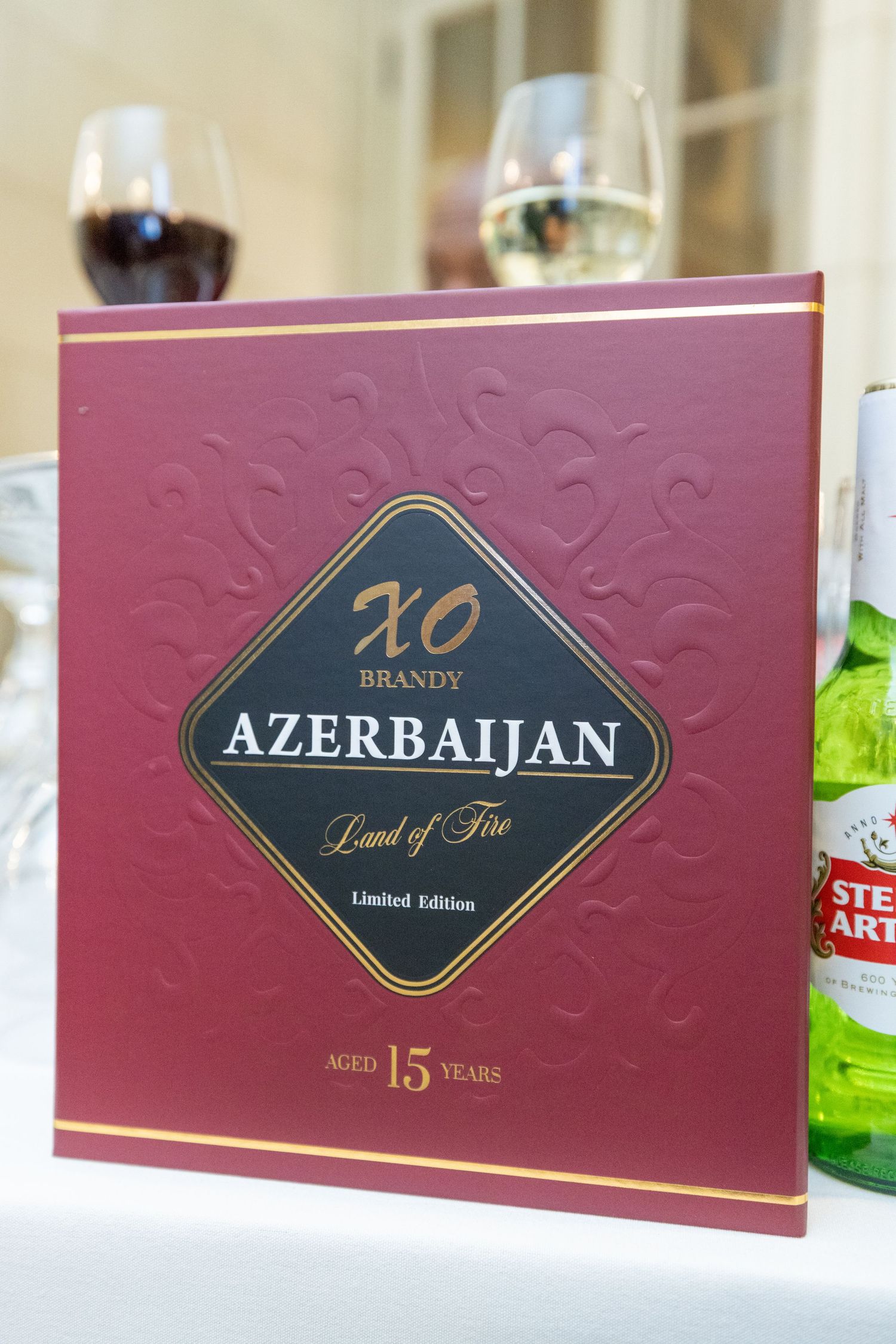 Close-up view of premium brandy packaging showing Azerbaijan XO branding in gold lettering on burgundy boxes.