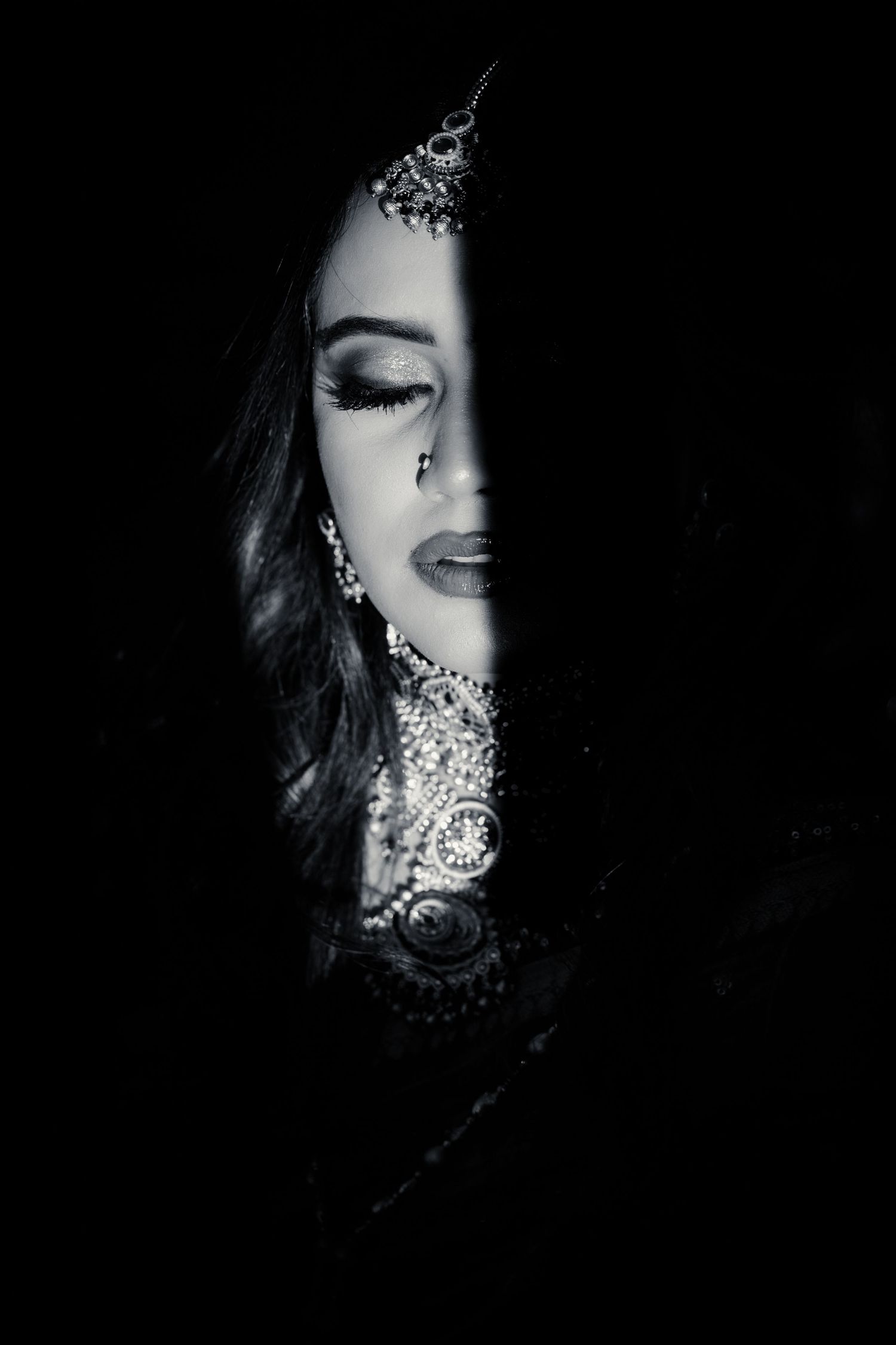 Artistic black and white portrait series showing half-lit faces with glitter makeup in dramatic shadows.