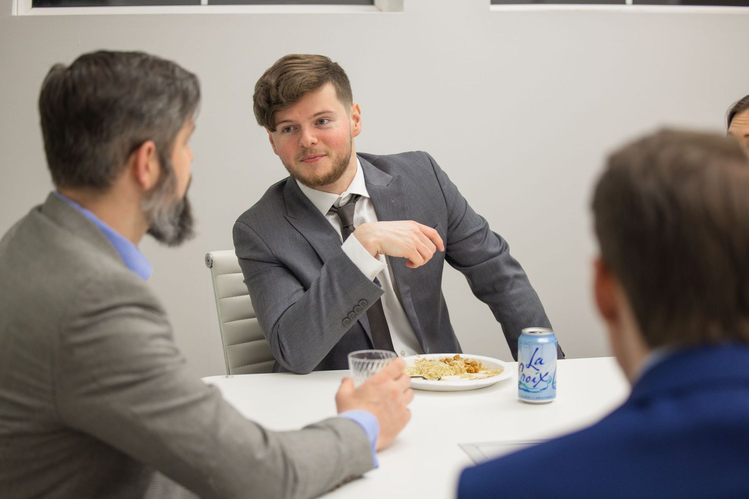 Business professionals engage in discussion around a conference table during a meeting.