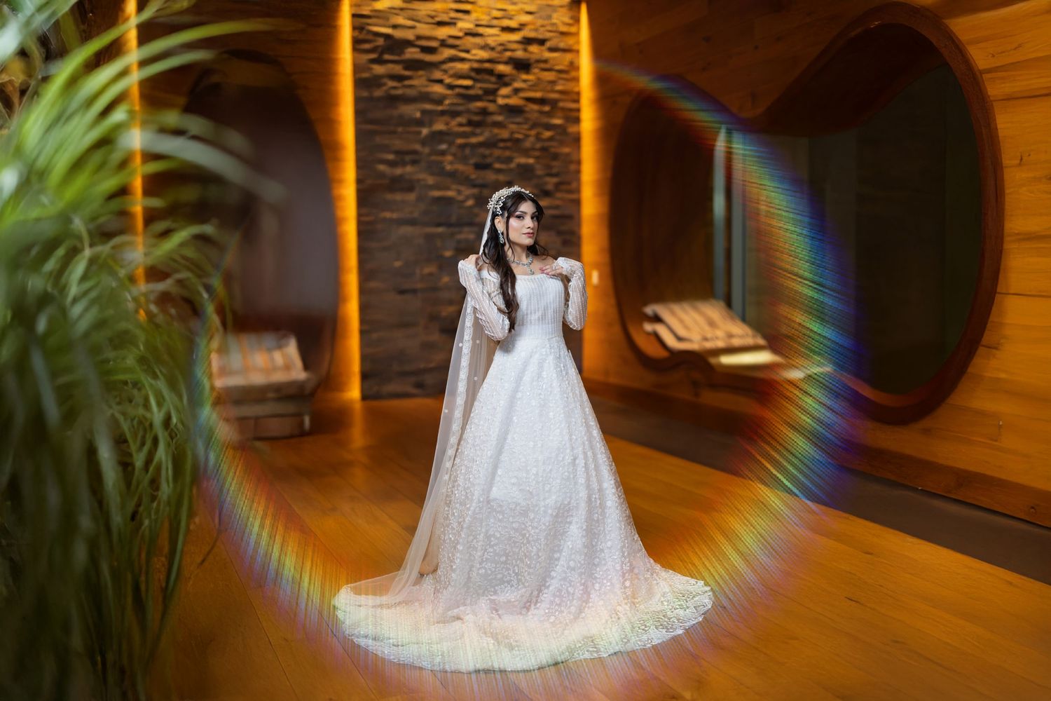 Long exposure circular rainbow light trail effect in a wooden hallway interior creates an ethereal spiral pattern.