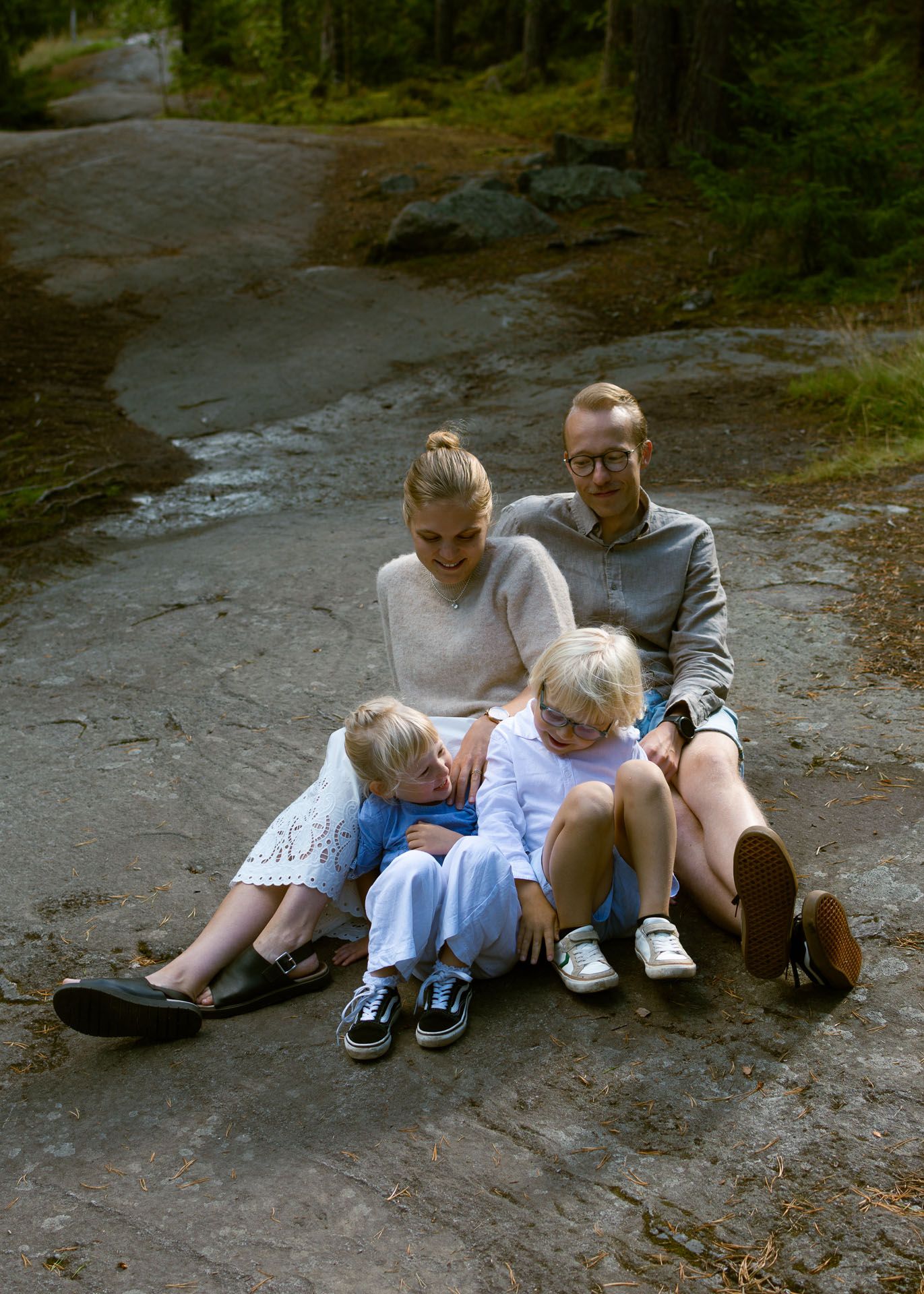 Perhekuva kalliolla olevasta äidistä, isästä ja kahdesta lapsesta.