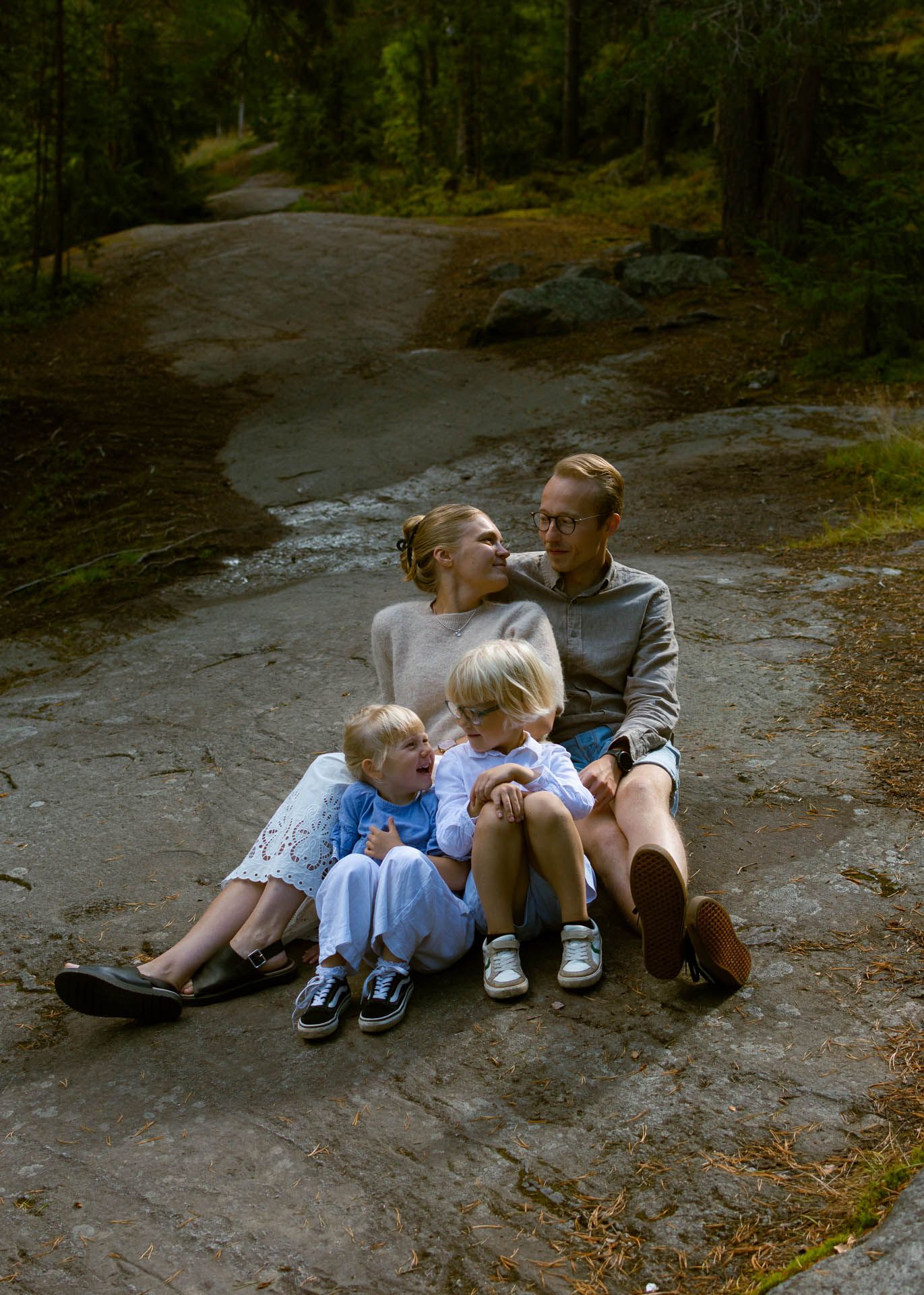 Perhekuva kalliolla olevasta äidistä, isästä ja kahdesta lapsesta.