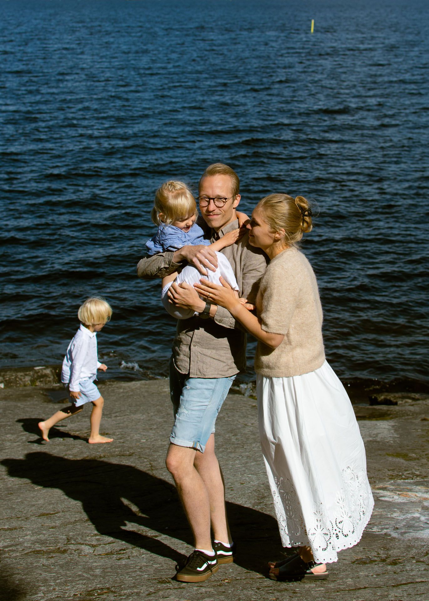 Perhekuva järven rannalla äidistä, isästä ja kahdesta lapsesta.