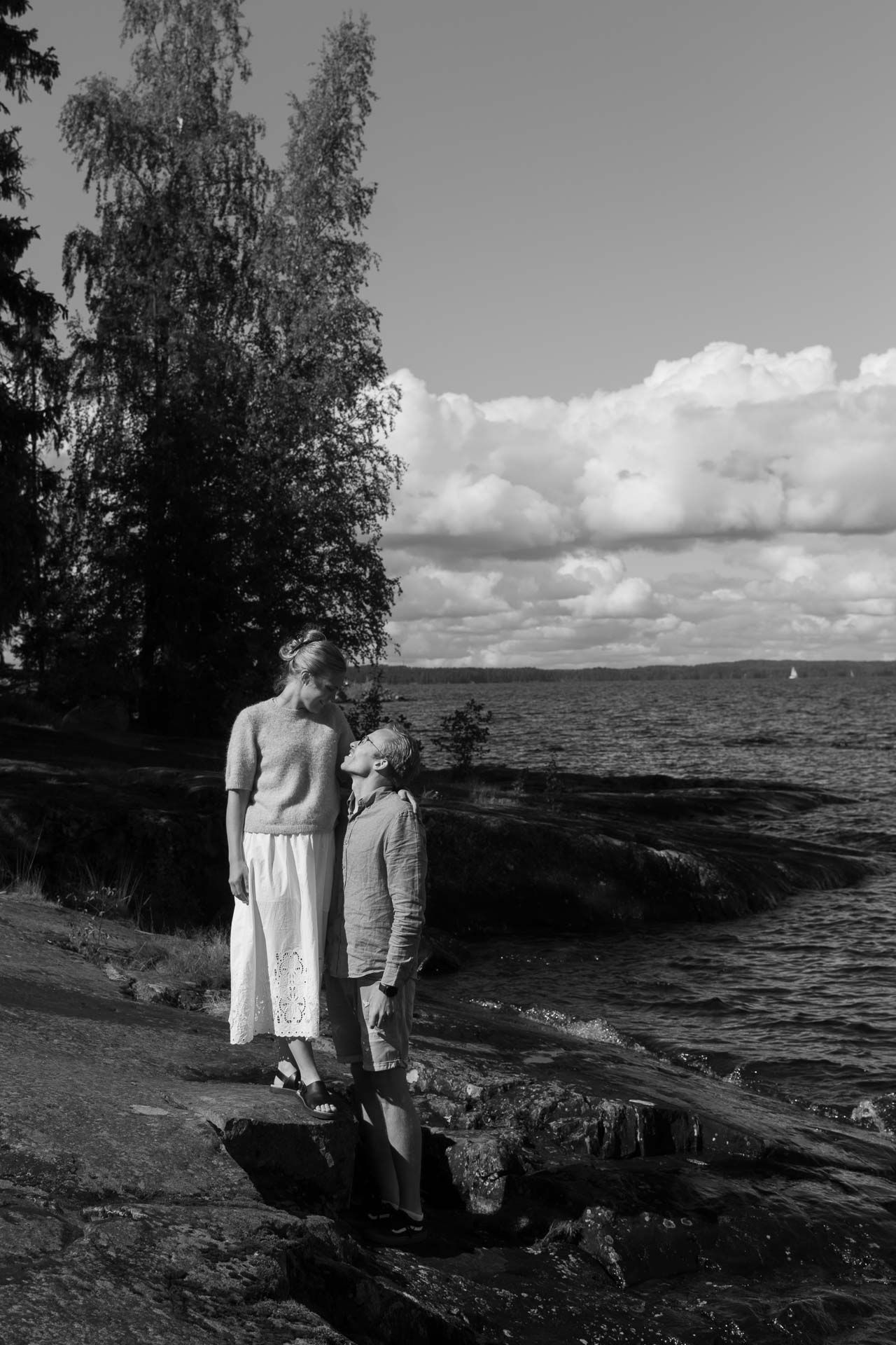 Pariskunta seisoo järven rannalla.