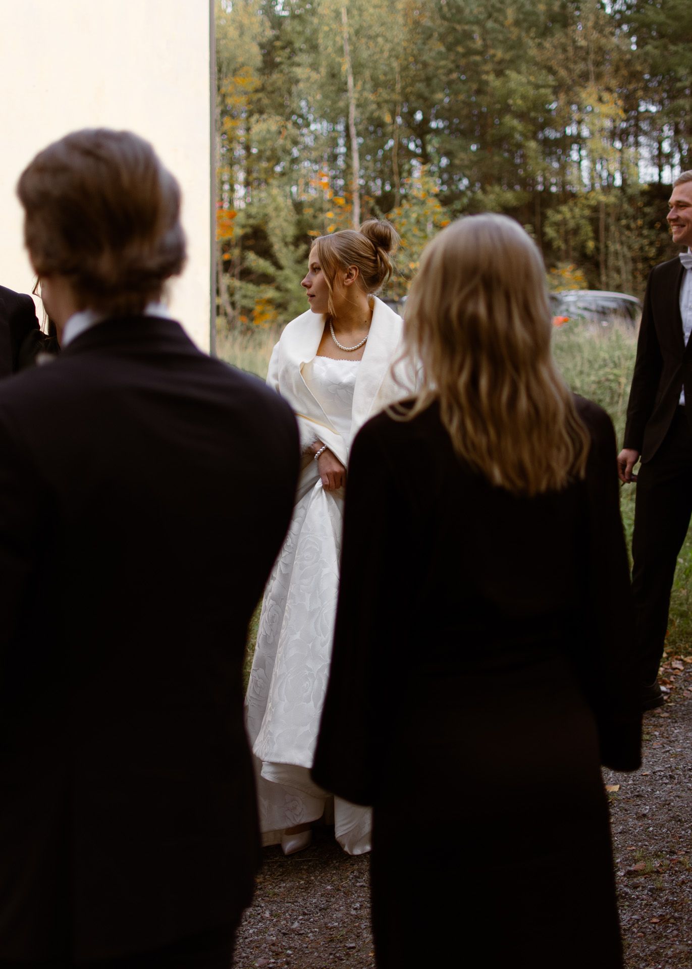 Morsian seurustelemassa häävieraiden kanssa ulkona.