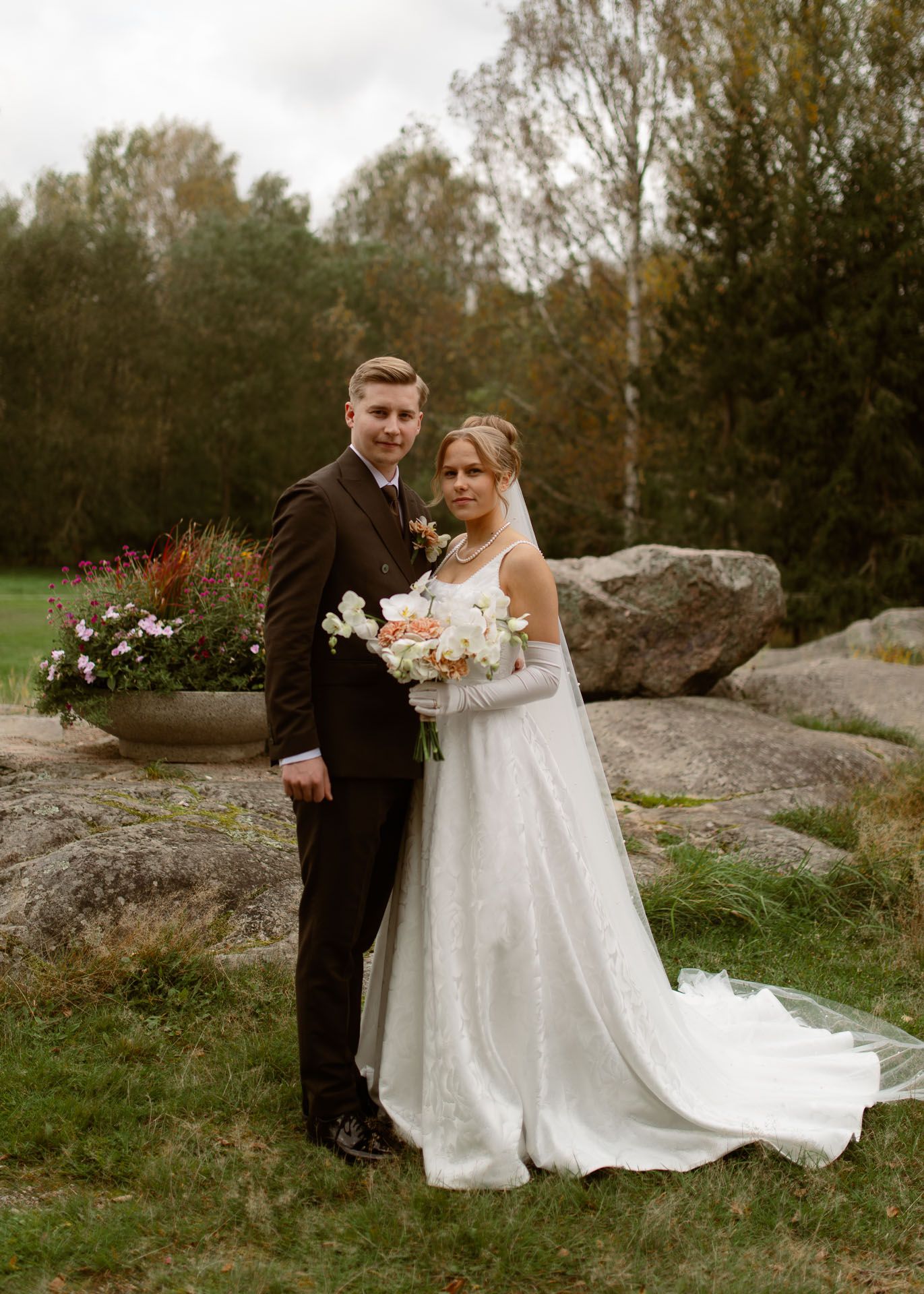 Hääpari yhteiskuvassa puistossa.