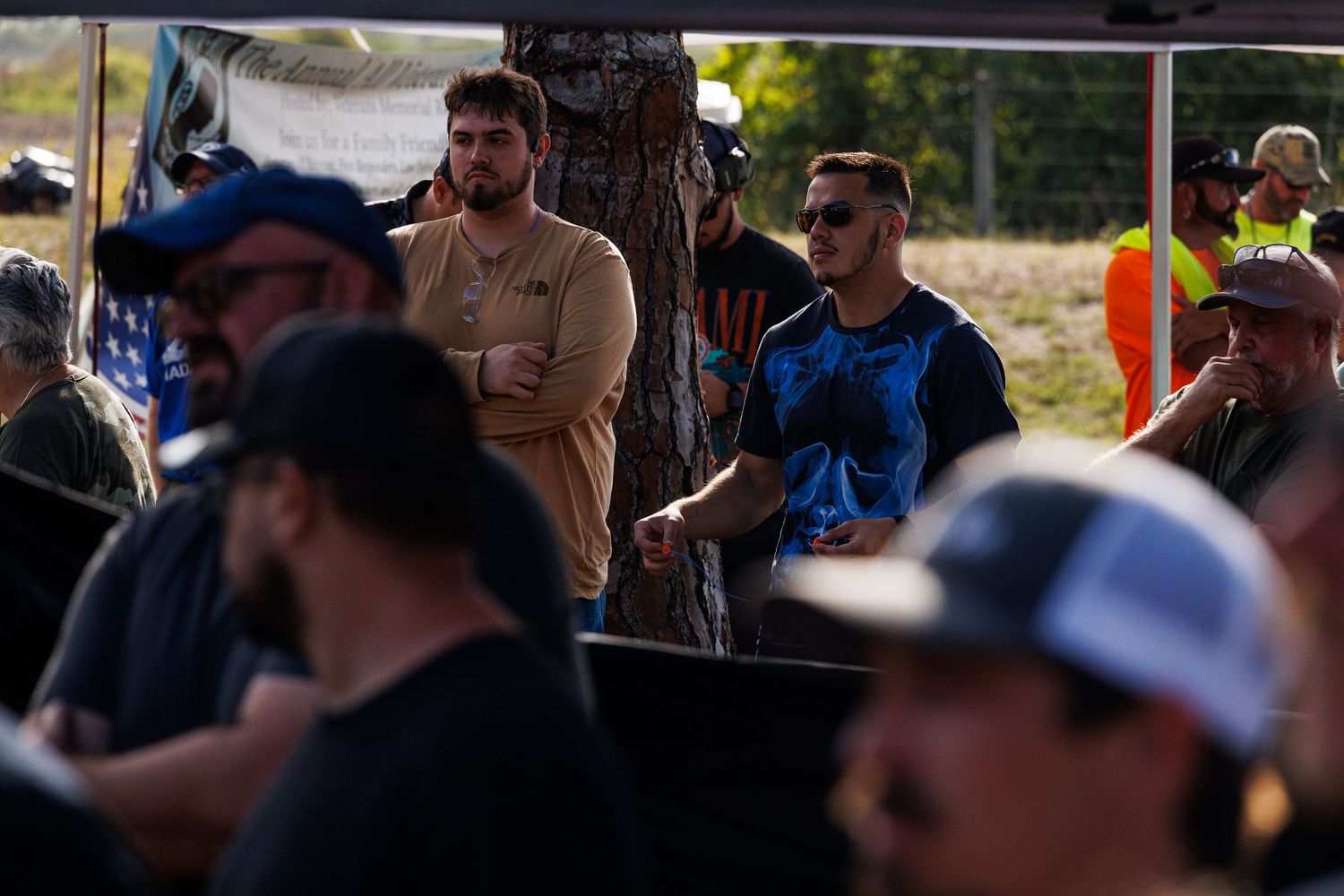 Group of participants gathered under a covered area at an outdoor event.
