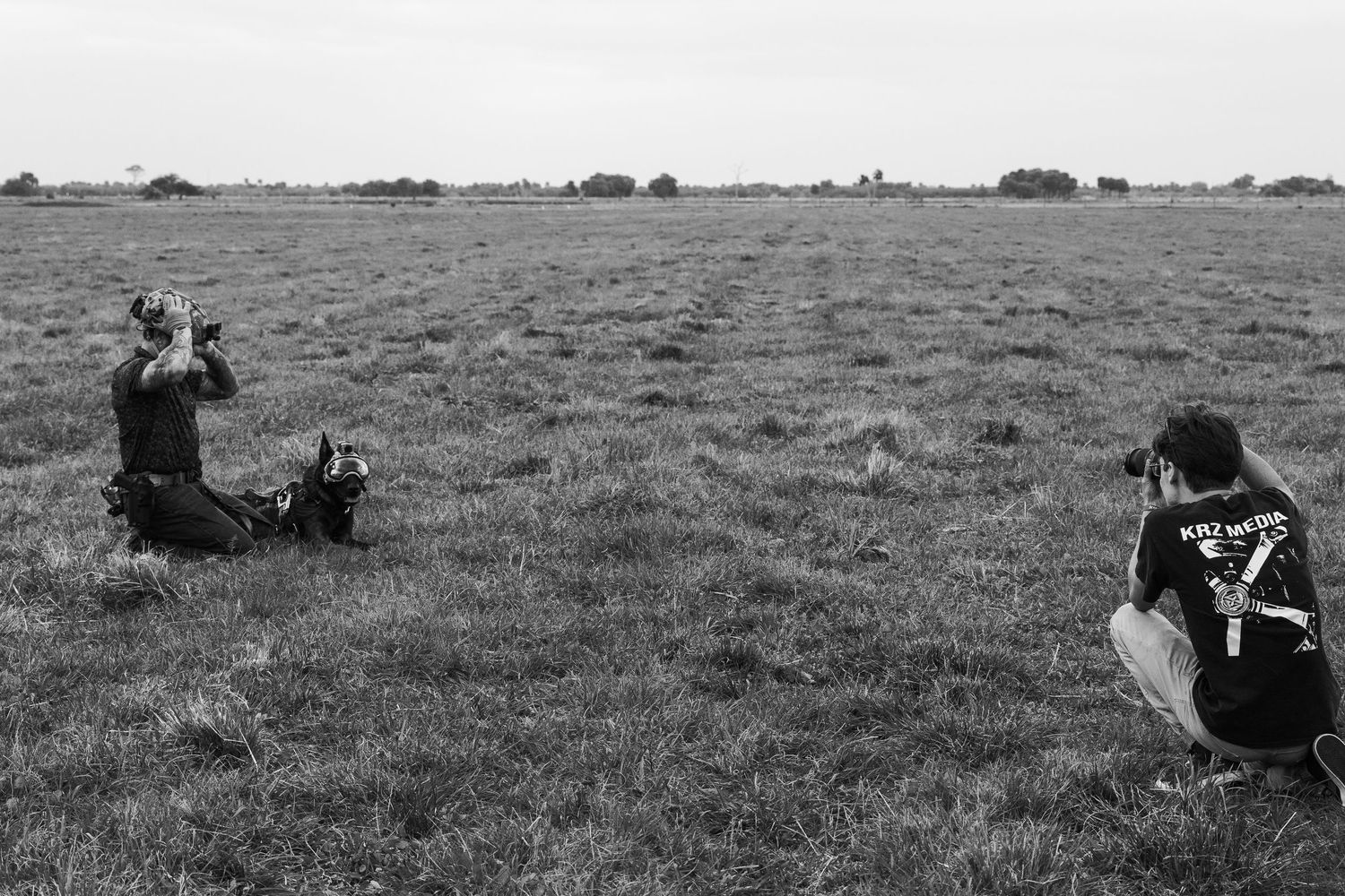 Wide angle view of people scattered across an open grassy field during an event.