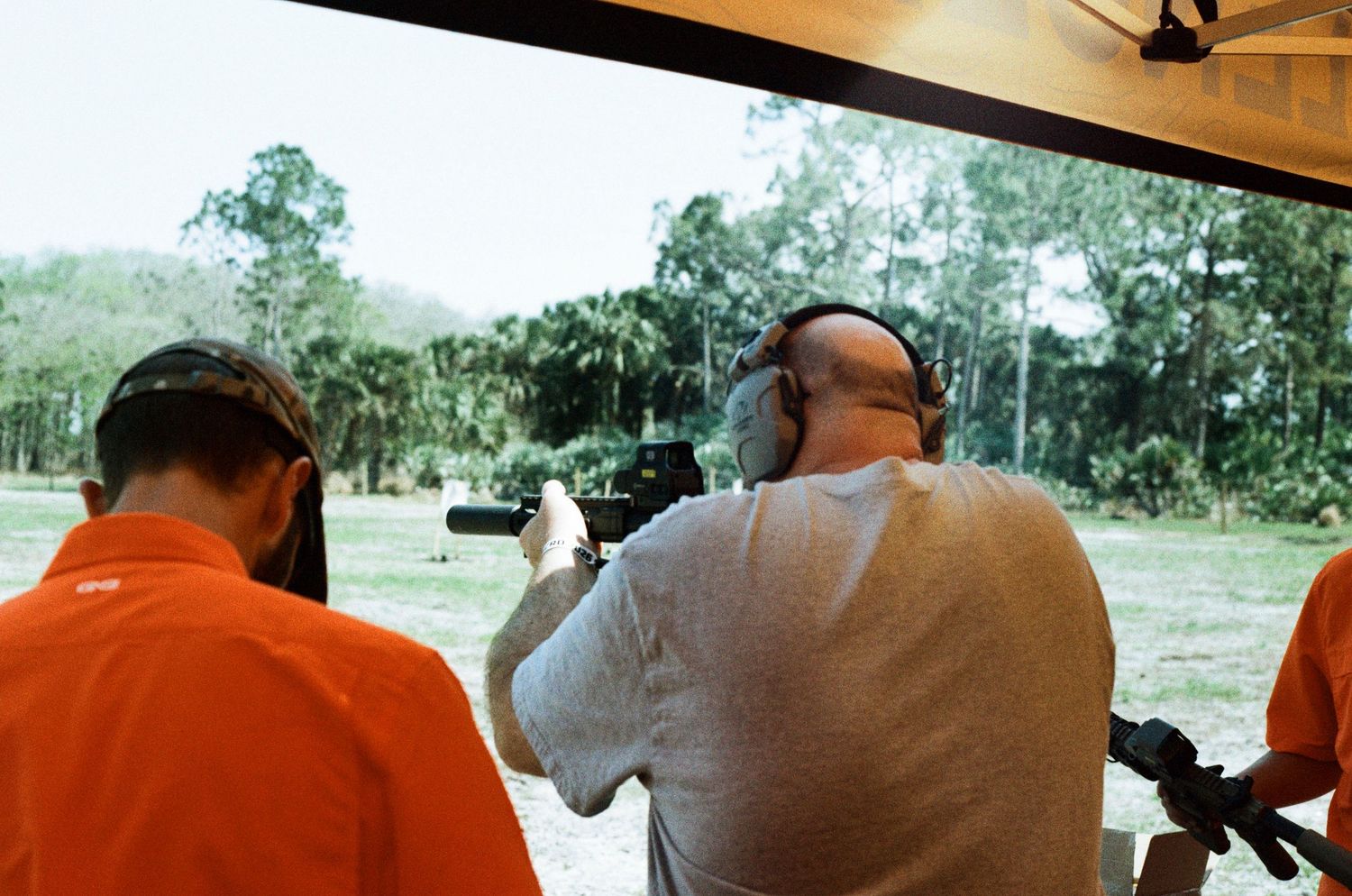 Shooters at an outdoor firing range taking aim downrange during a range day event.