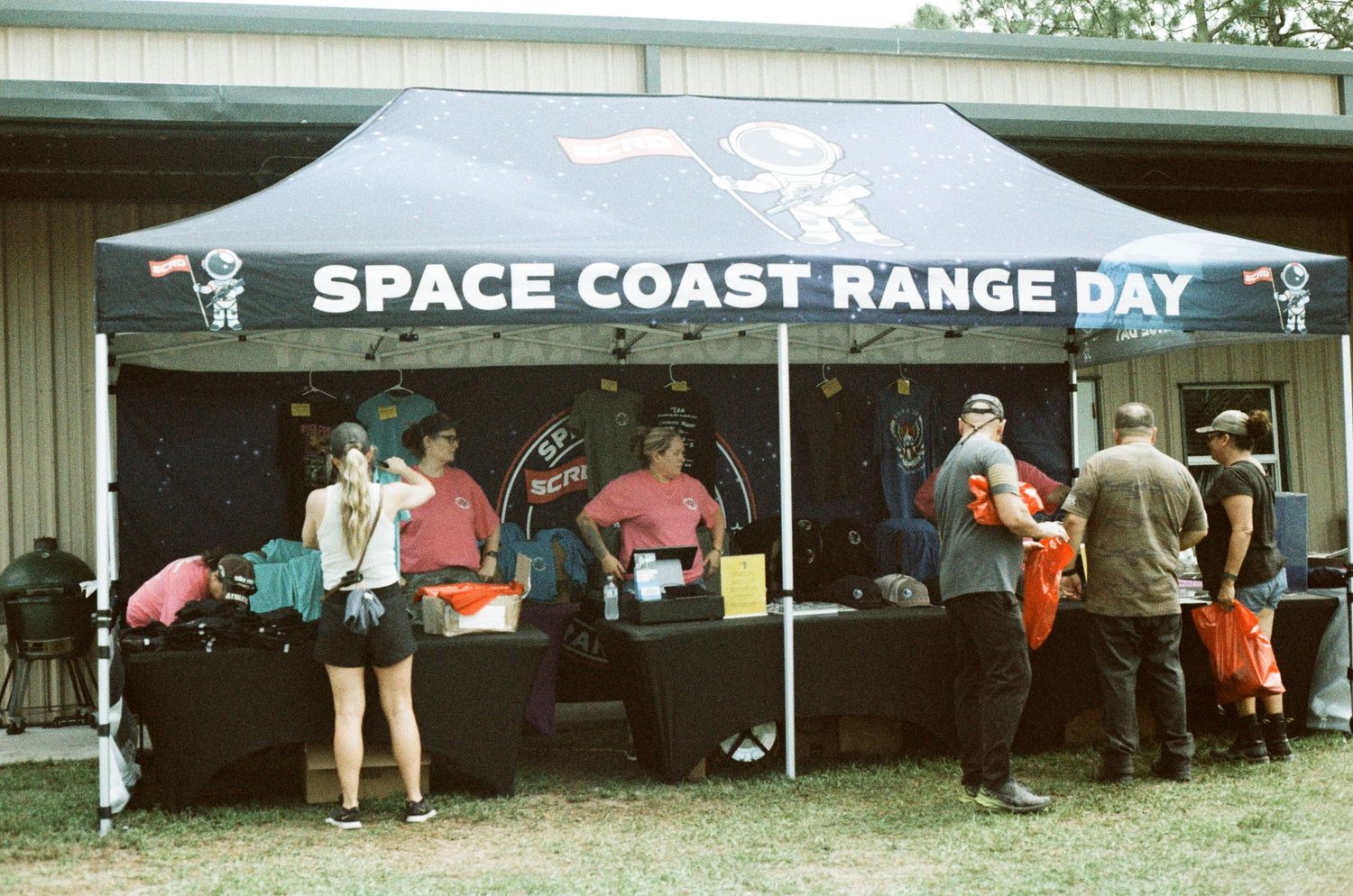 Space Coast Range Day vendor tent with merchandise displays at outdoor event.