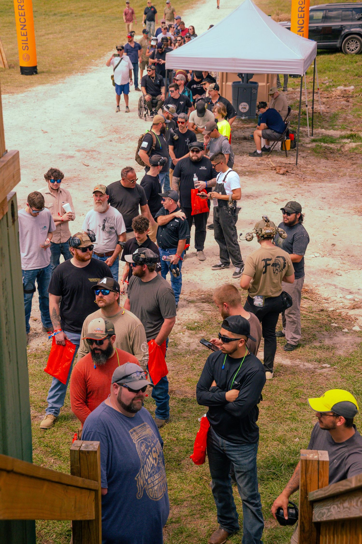 Large group gathered outdoors under tent during training or event.