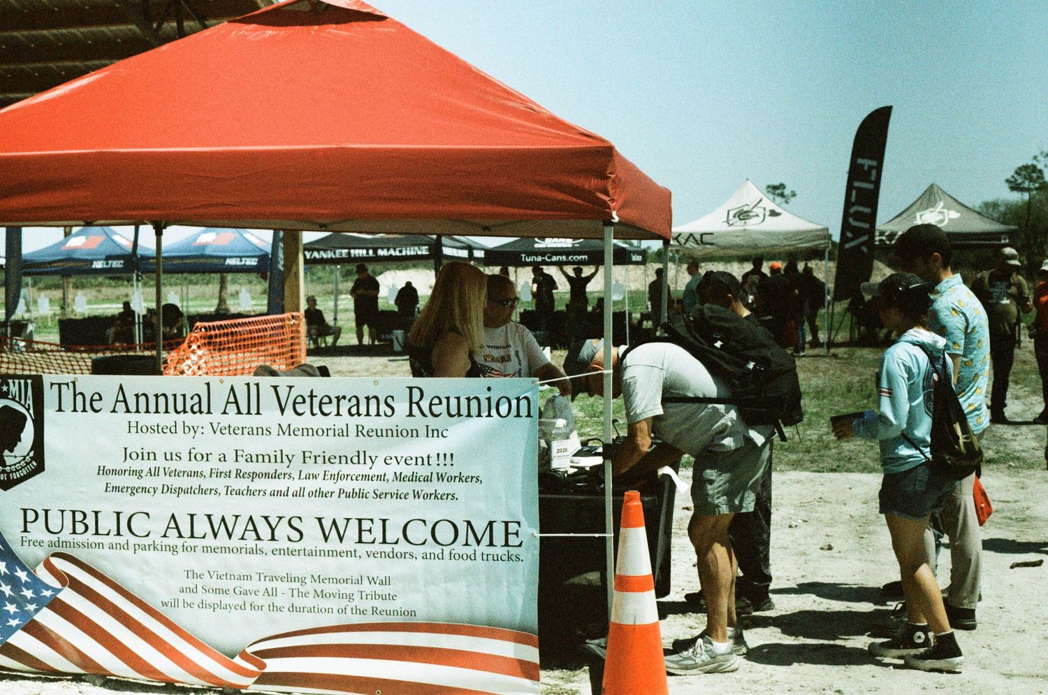 Annual All Veterans Reunion outdoor event with red canopy tent and welcome signage.