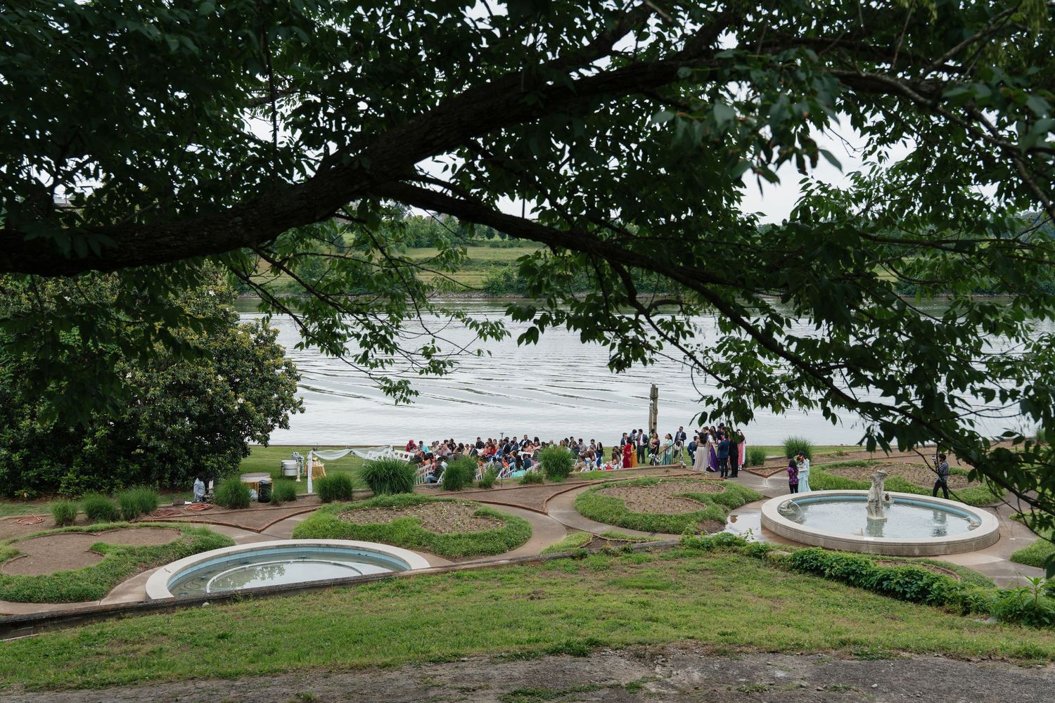 Aerial panoramic view of a park landscape with winding paths and scattered groups of visitors.
