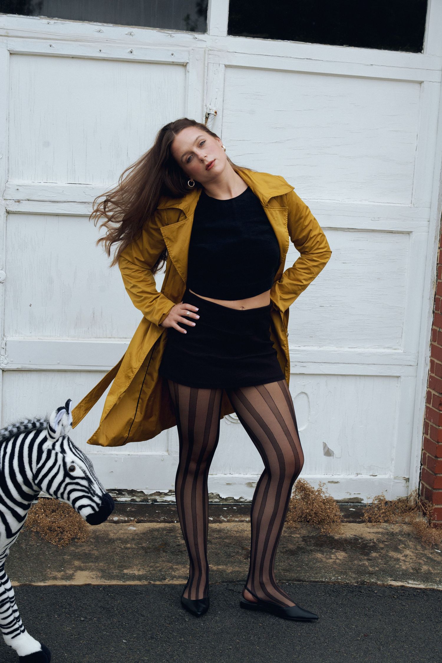 A fashion sequence shows a model in black and yellow outfit with tights against a white wall backdrop.