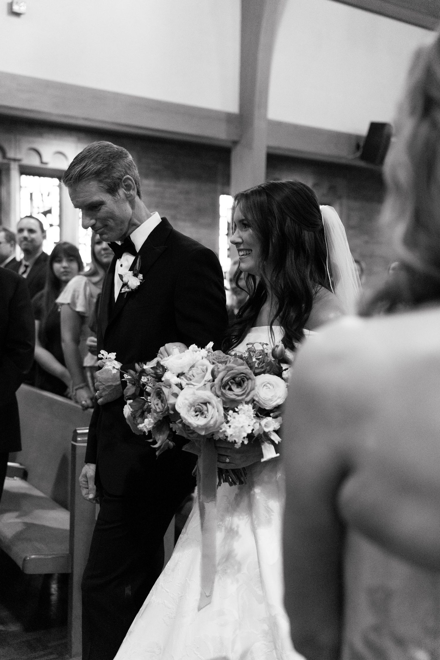 A black and white series of wedding ceremony moments showing a bride and father walking down the church aisle.