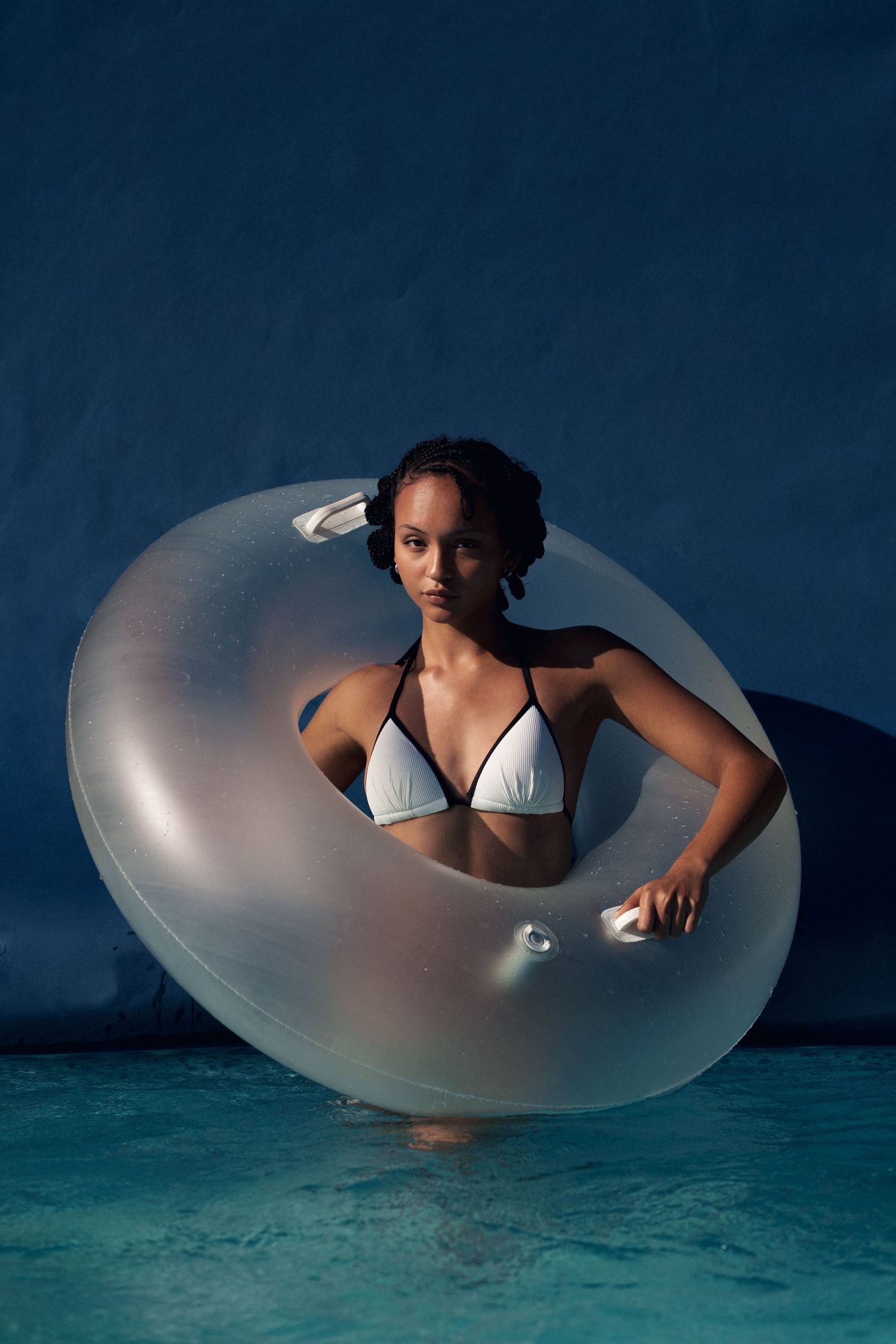 Sequential photos show a person floating in a semi-transparent inflatable ring in dark blue swimming pool water.