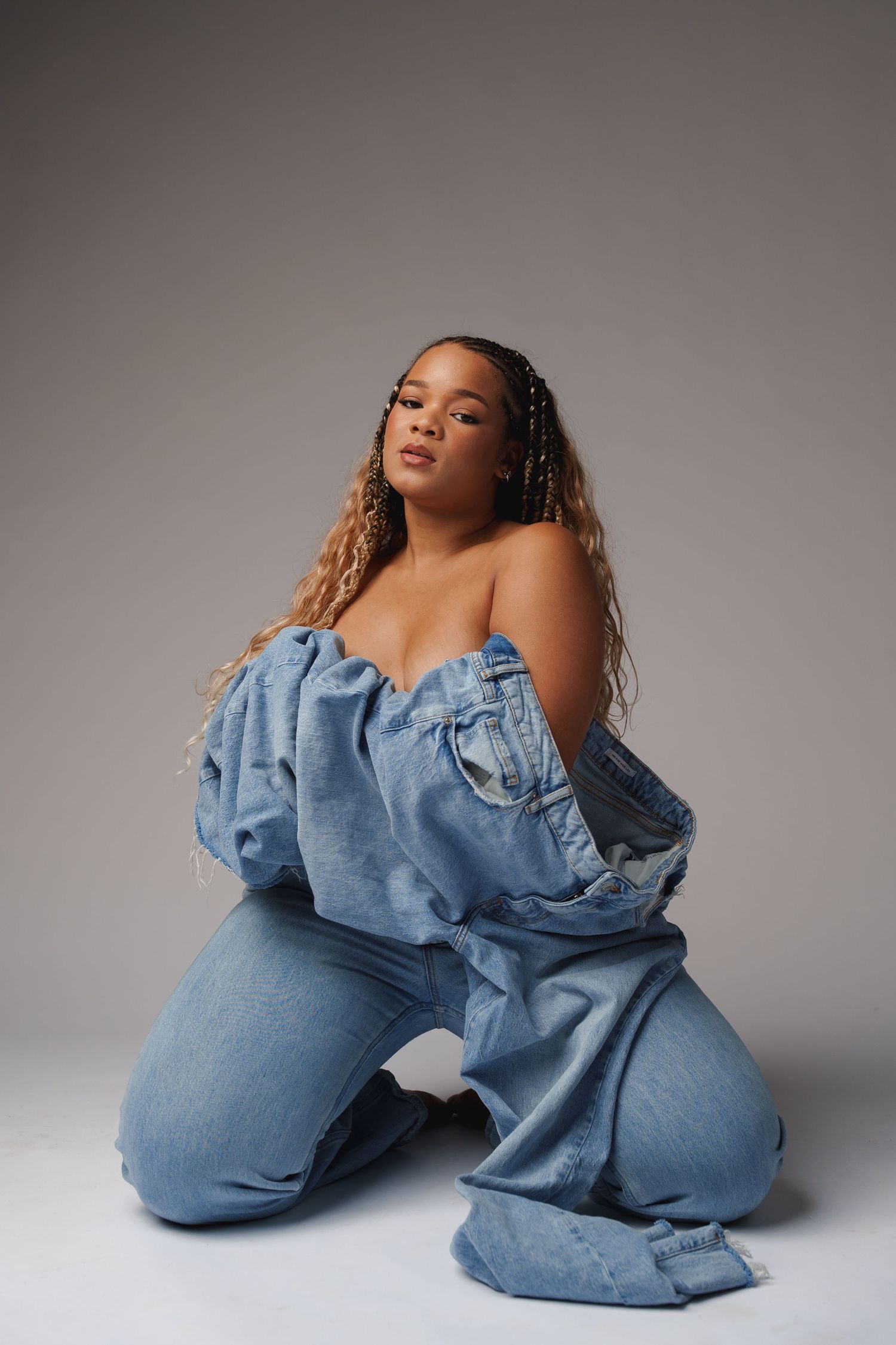 A series of artistic fashion photos showing a person posing in blue denim against a neutral gray backdrop.
