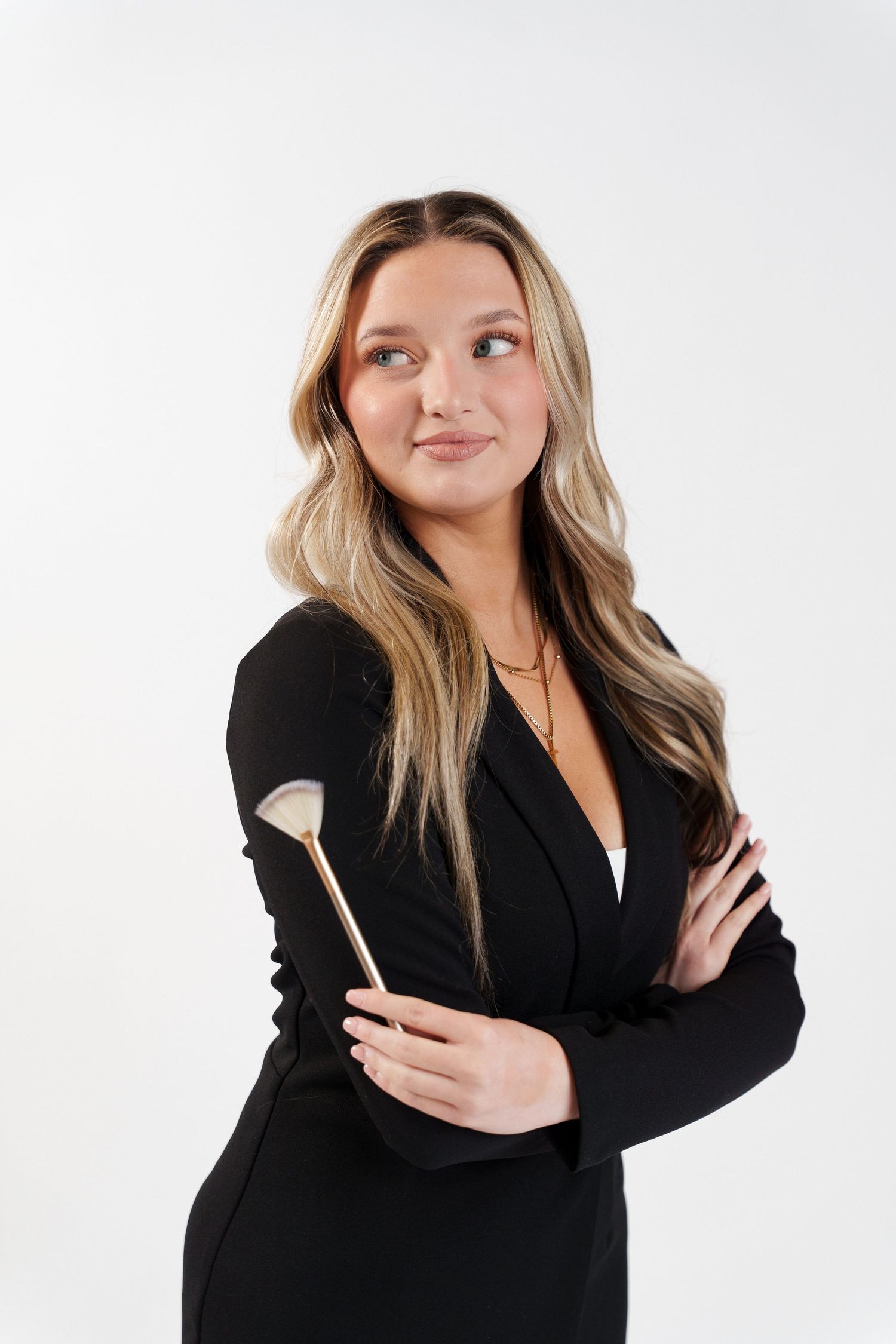 Professional headshots in black blazer against white backdrop with casual poses.